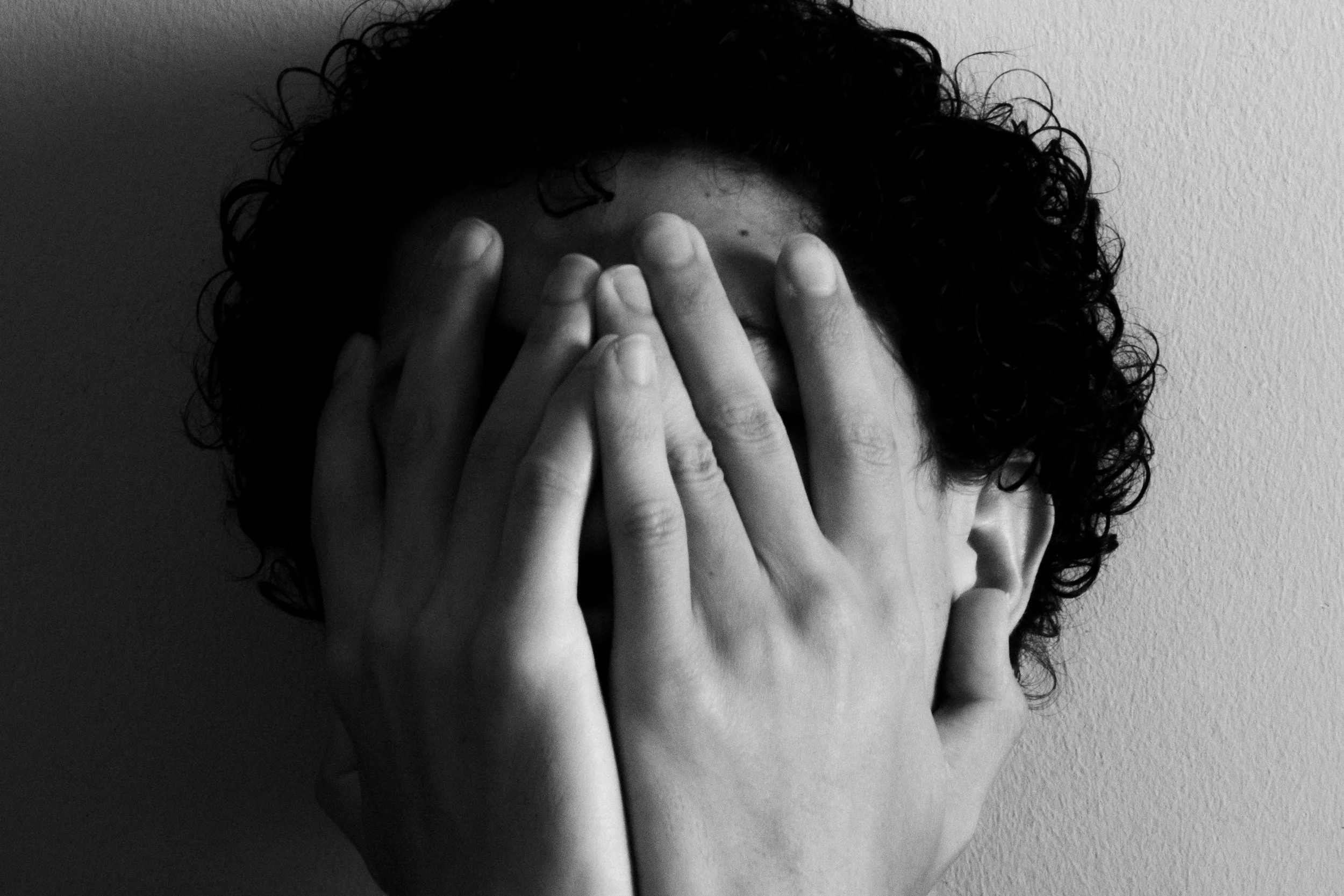 Person with head in hands in black and white photo