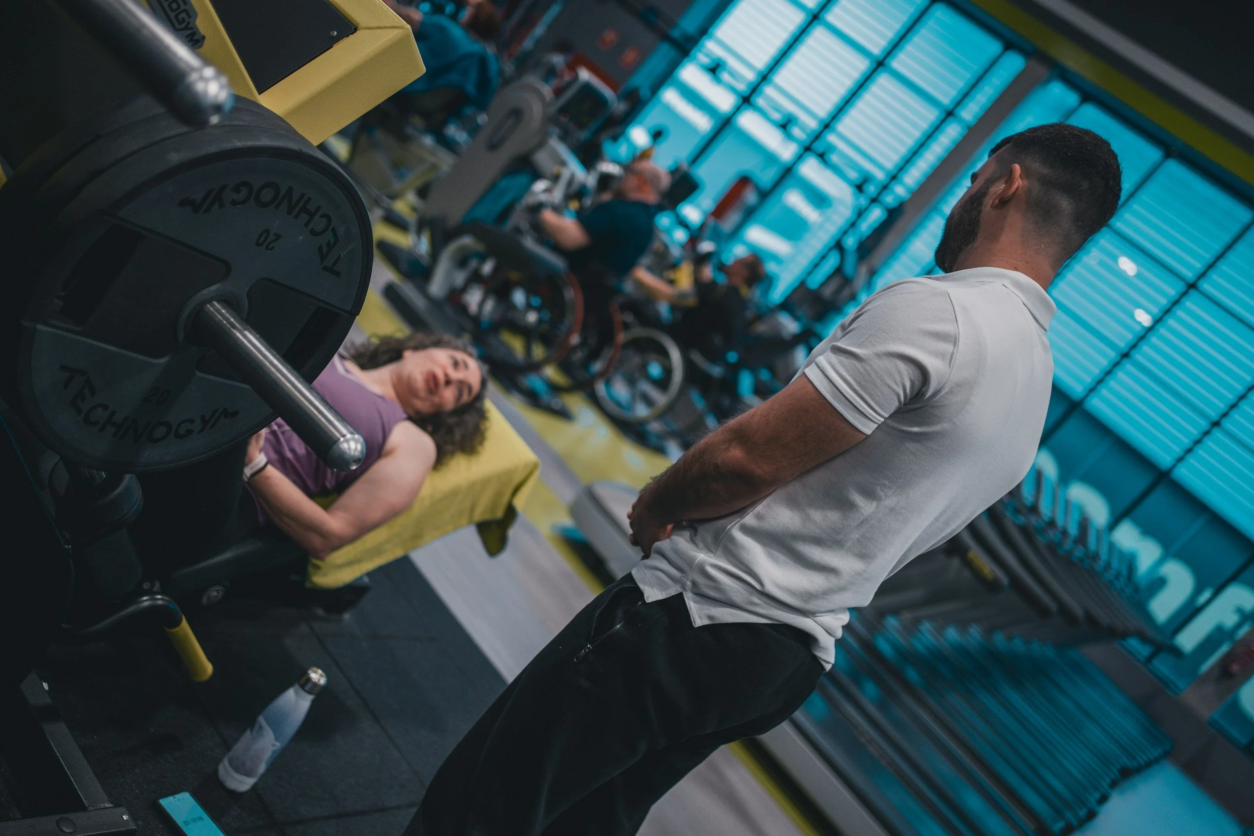 woman performing leg press while trainer looks on