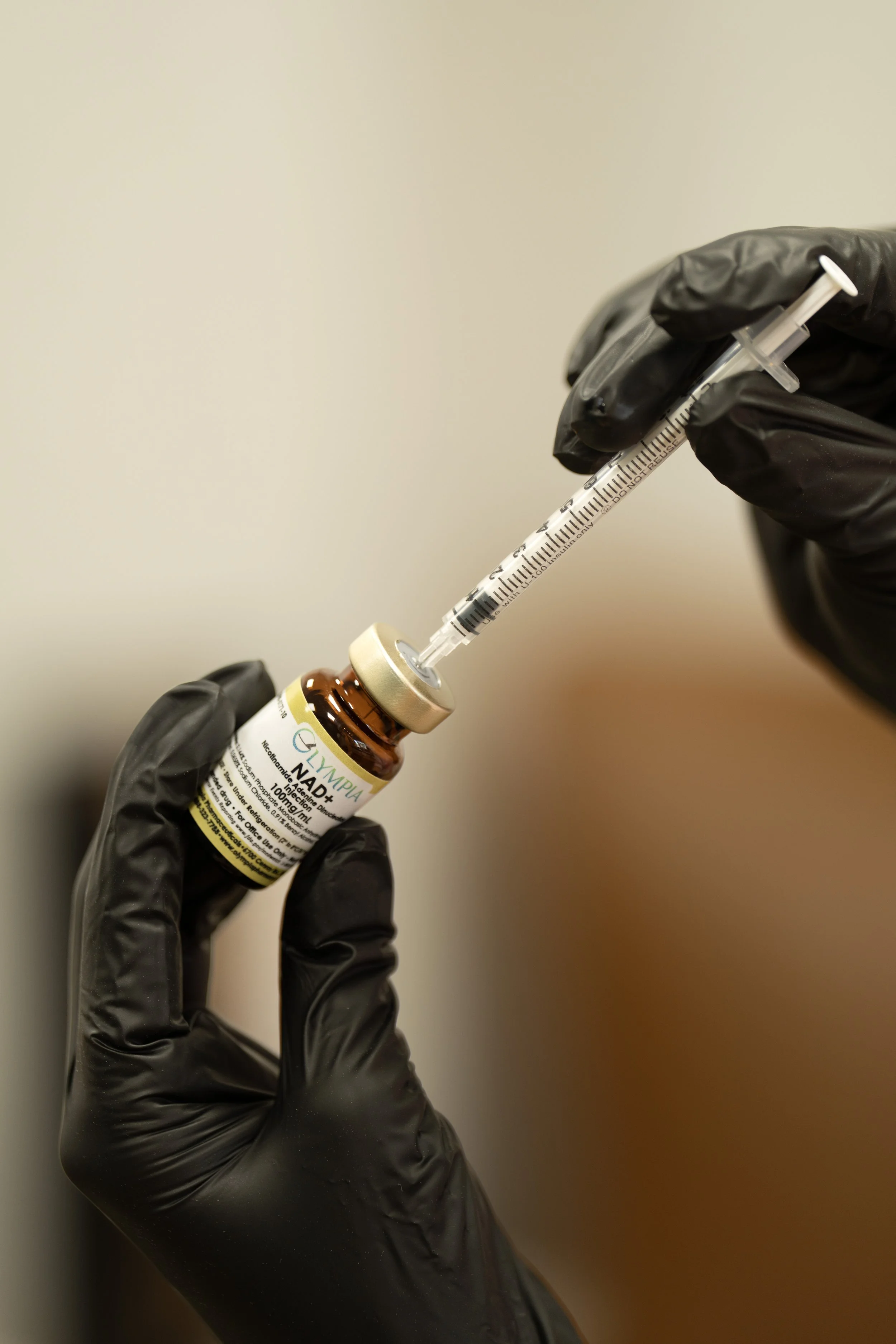Gloved hands drawing NAD+ injection into a syringe at The West Wellness and Massage in Fort Worth
