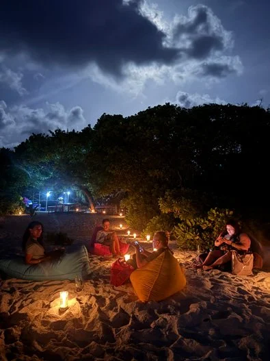 モルディブの無人島で夜のBBQを楽しむ人々とキャンドルの灯り