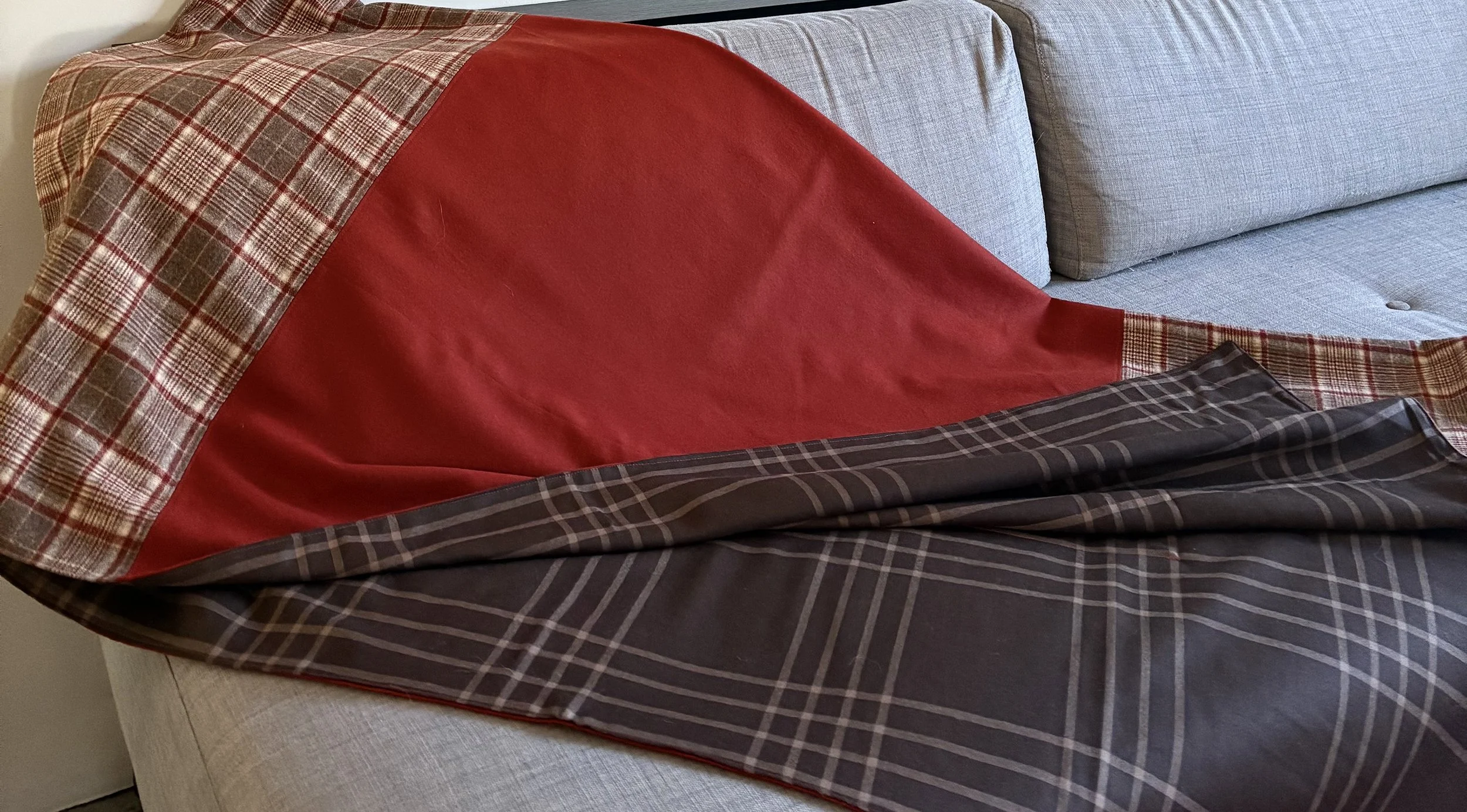 60" x 60" throw of Pendleton wool in rust and rust and brown 3" plaid on one side, and a large 6" brown and cream plaid on the other side.