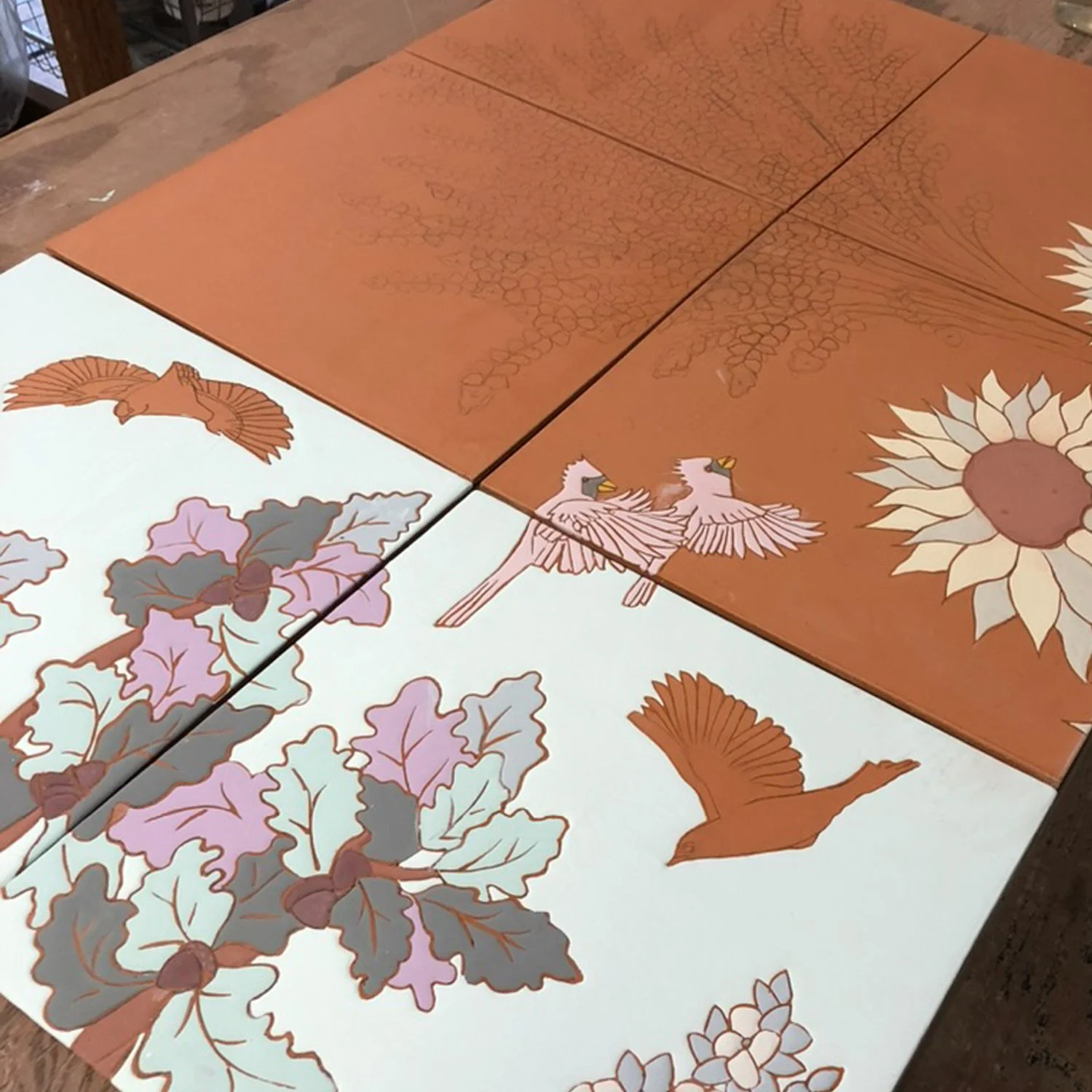 Partially glazed mural of trees, bluebirds, and finches flying.