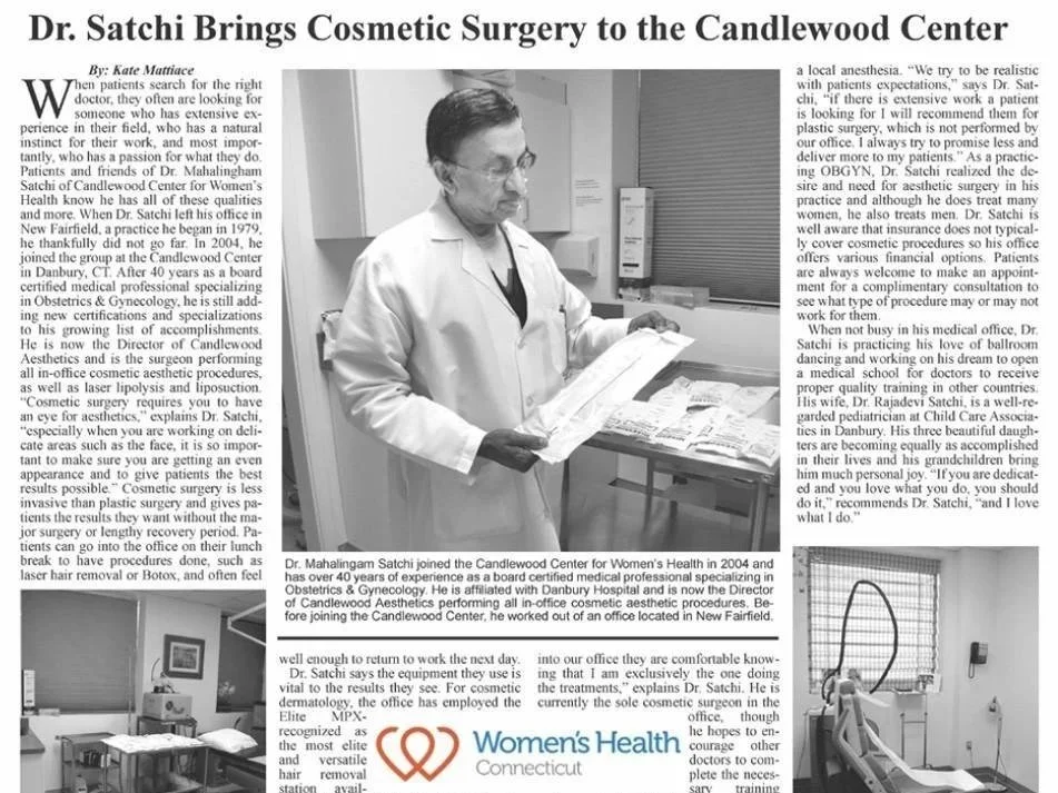 Black-and-white photo of Dr. Mahalingam Satchi in a clinical setting holding a paper, with medical equipment and a computer monitor in the background, during a cosmetic surgery consultation or preparation.