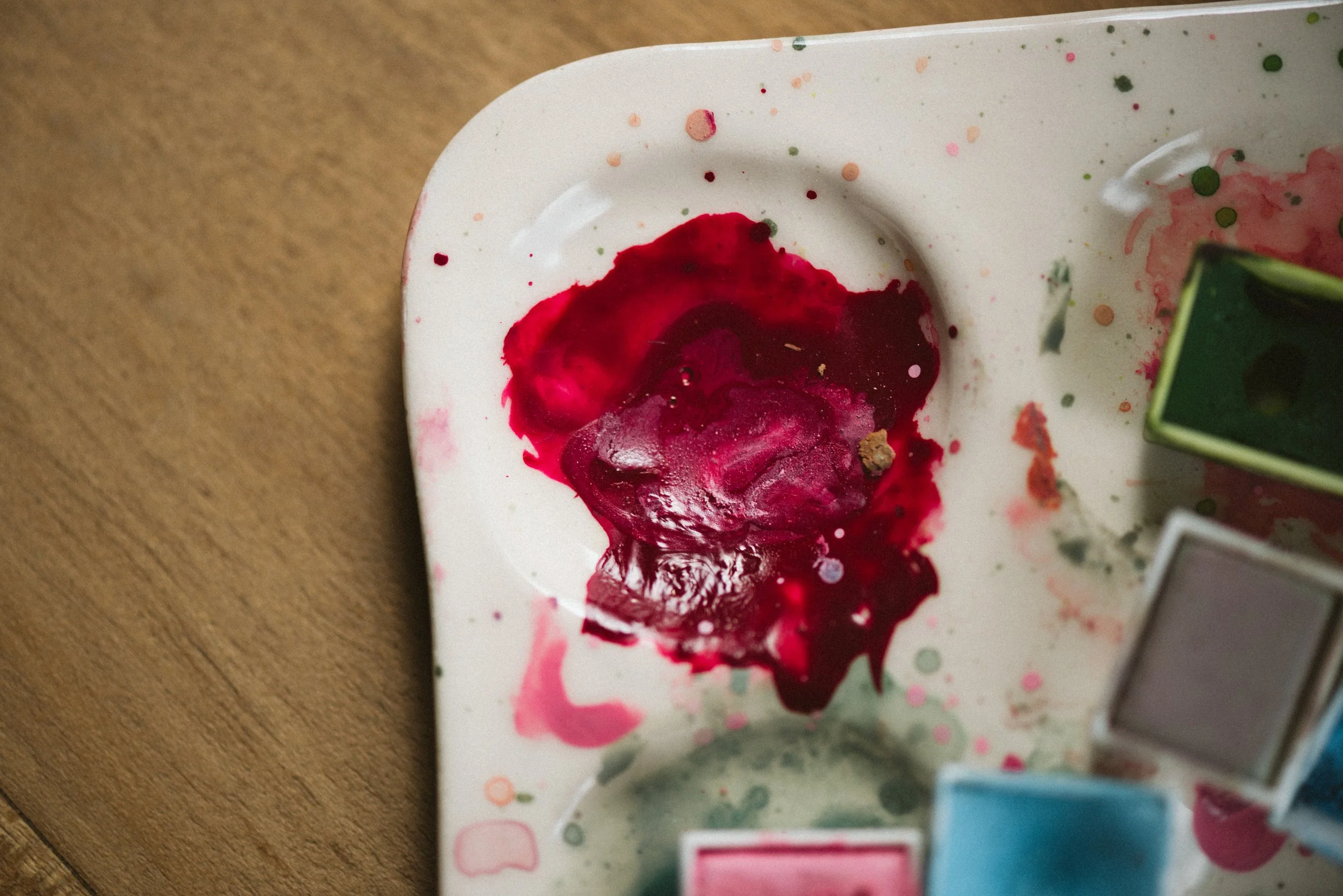 Man wearing a red blazer, black tie, and black pants standing against a white background.