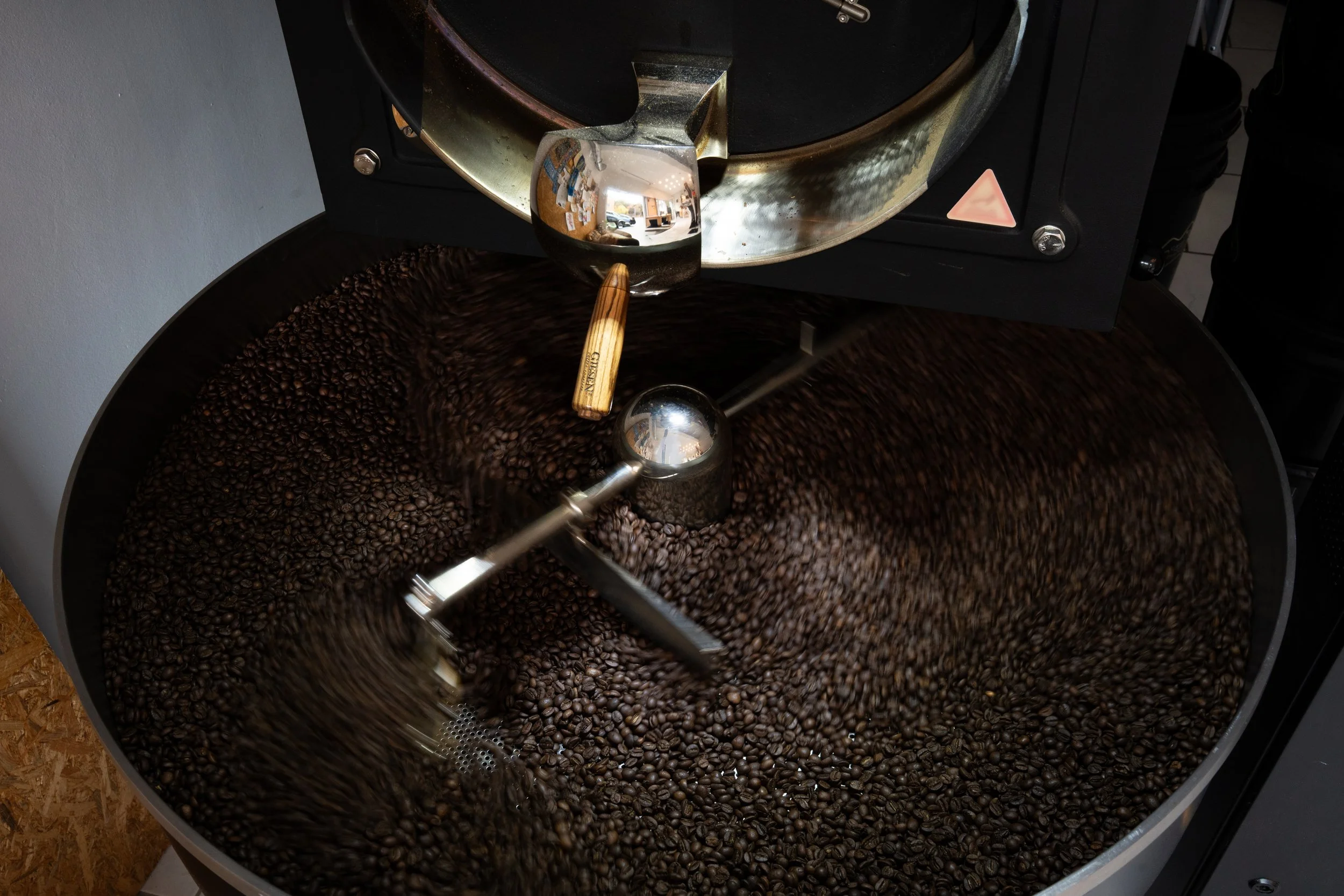 In diesem Bild sieht man frisch geröstete Kaffeebohnen, die gerade durchgemischt werden.