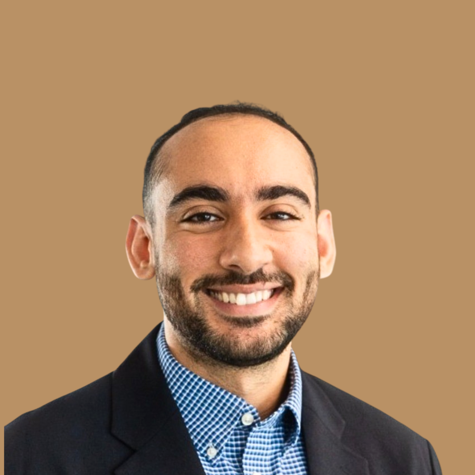 Headshot of a smiling man with dark hair, beard, wearing a suit and checkered shirt against a plain tan background.