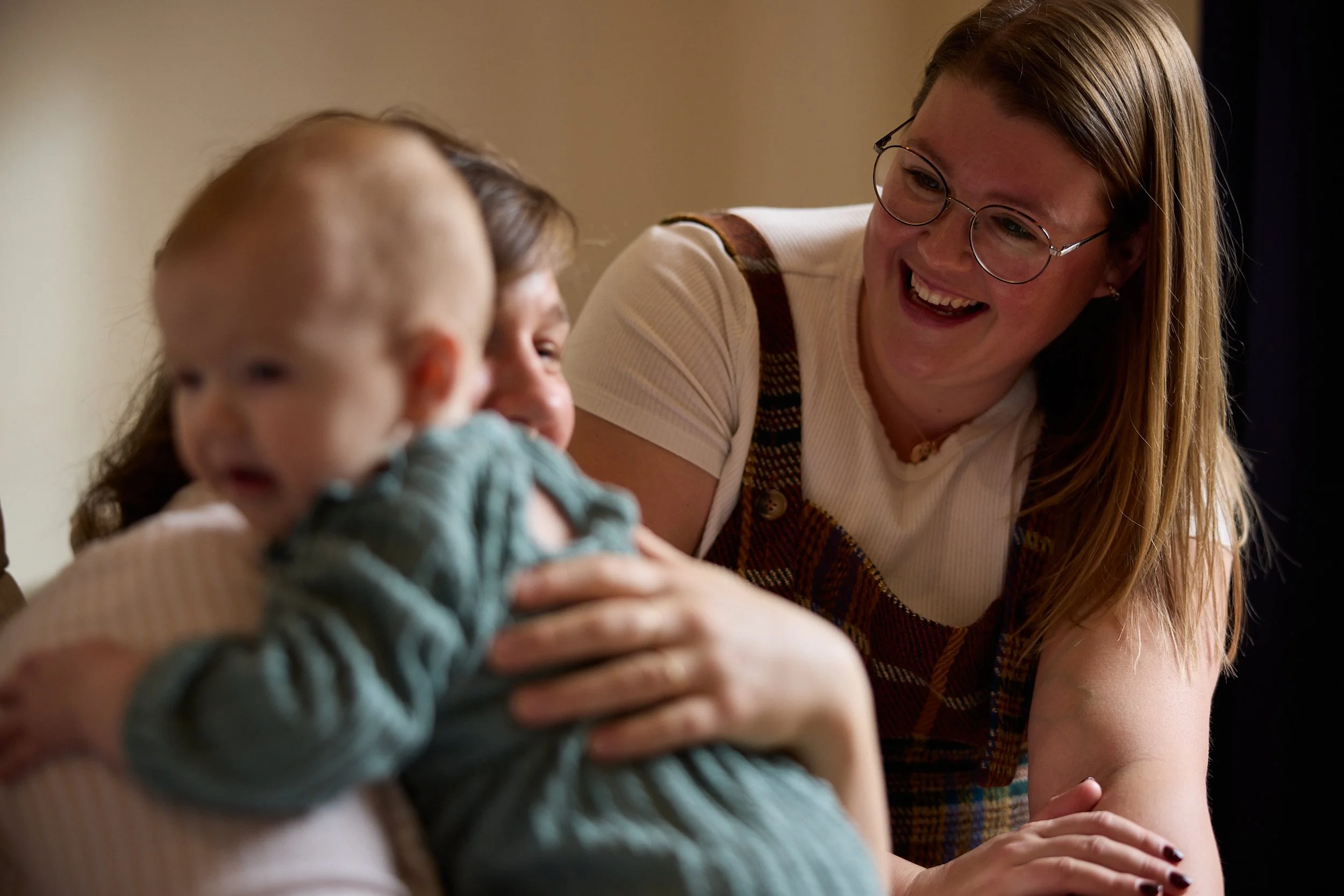 Lactation Consultant offering a calming presence to a new mom and her fussy baby in their home