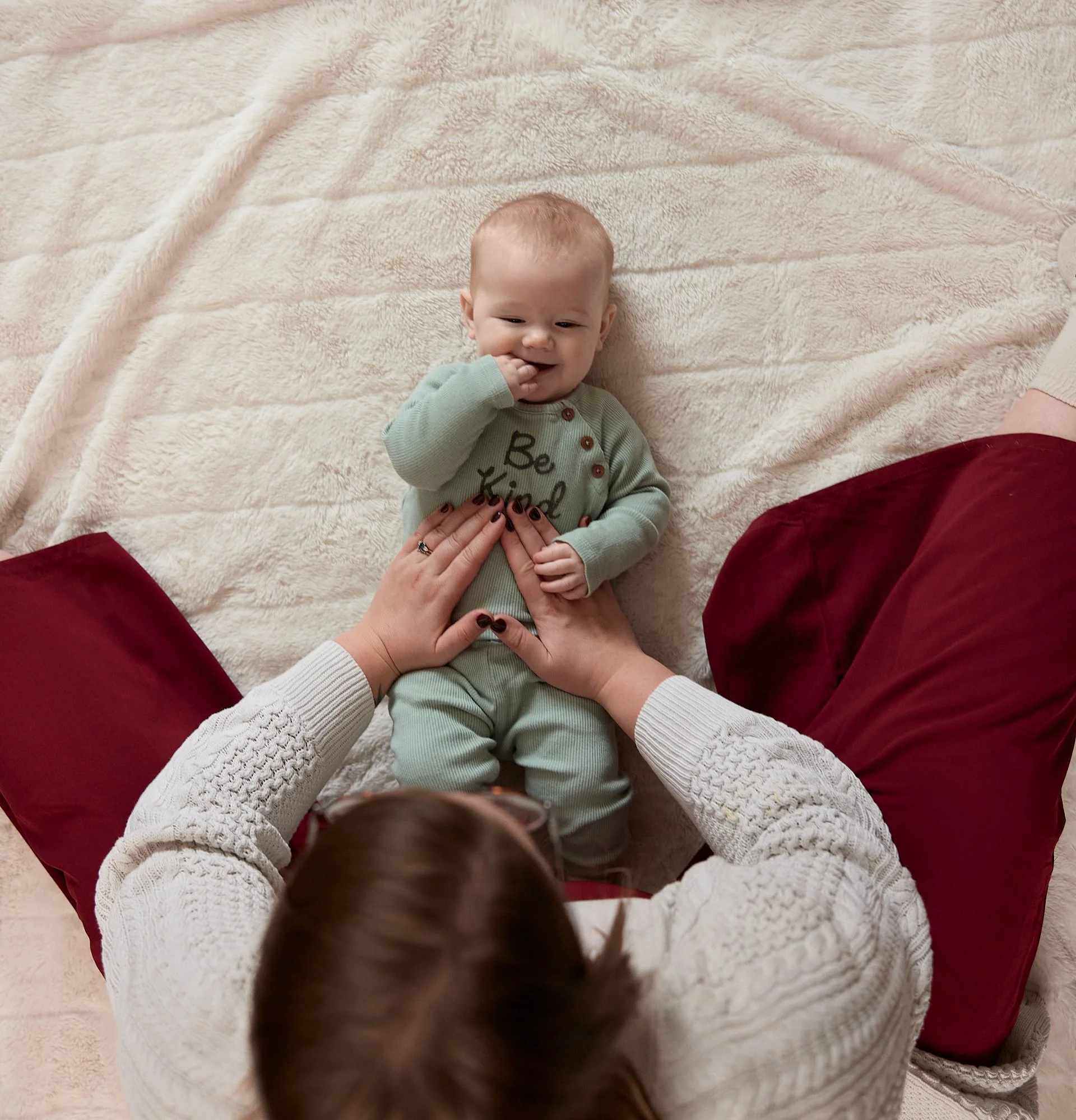 A Registered Massage Therapist doing gentle infant massage to help a gassy baby in their home in Brantford Ontario