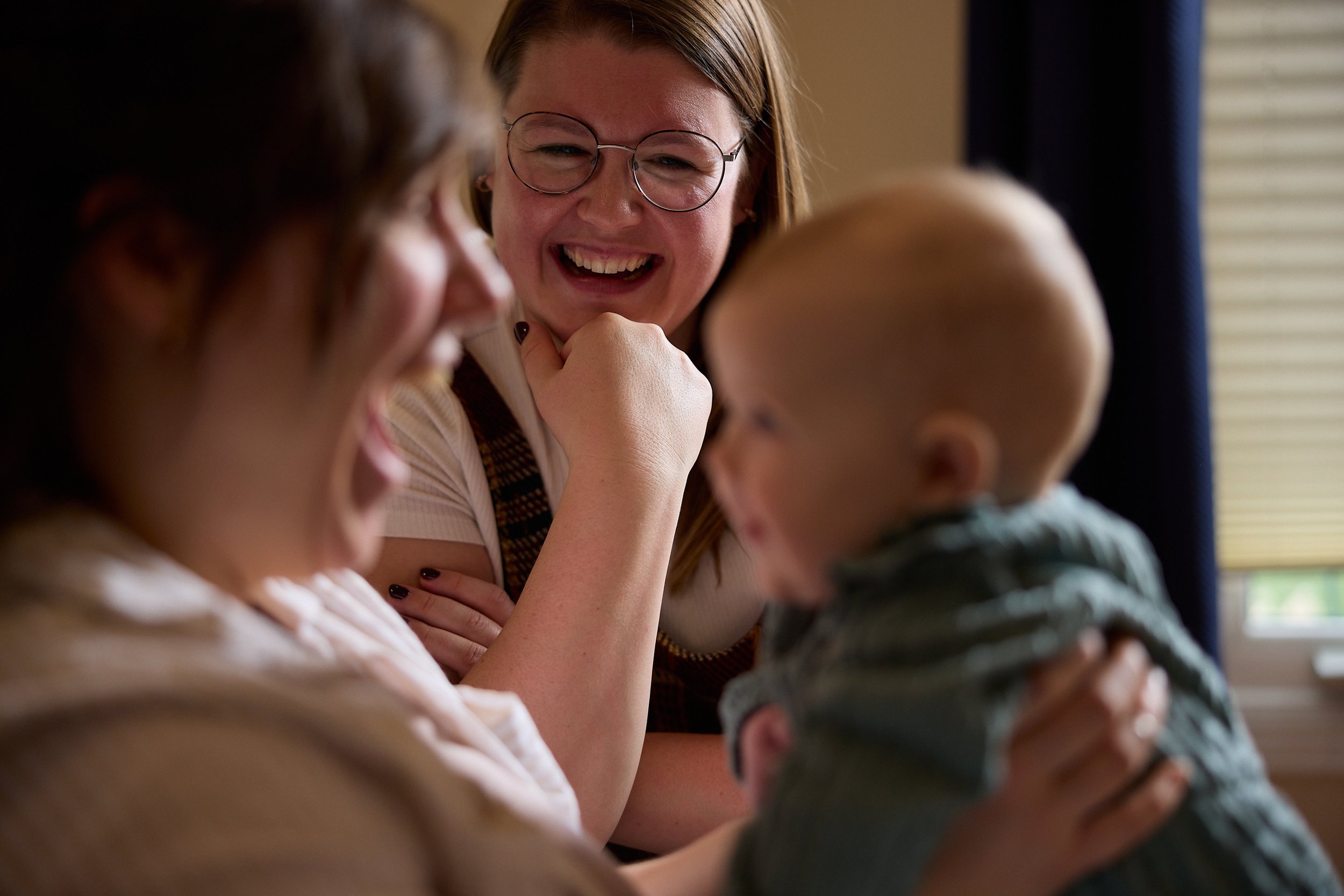 A Lactation Consultant smiles at her new mom and baby clients who are smiling after learning how to increase milk supply.