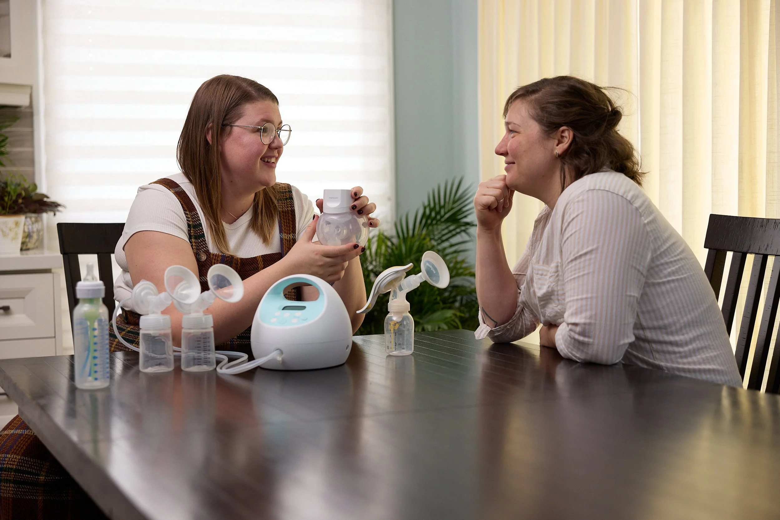lactation consultant showing a new mom various breast pump options and talking about how to use breast pumps