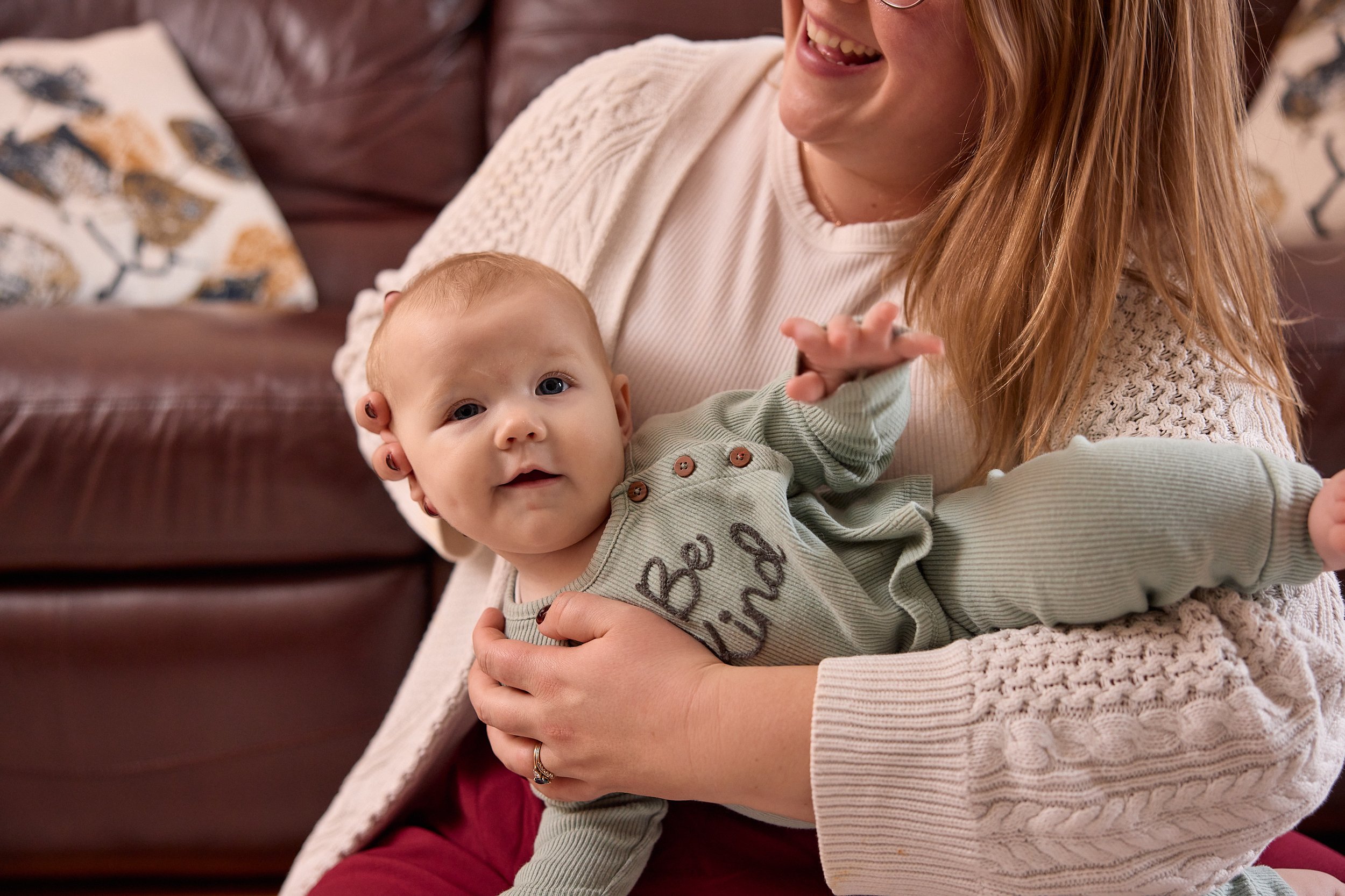 A Registered Massage Therapist is providing a neck stretch to a tongue tied baby with infant massage therapy.