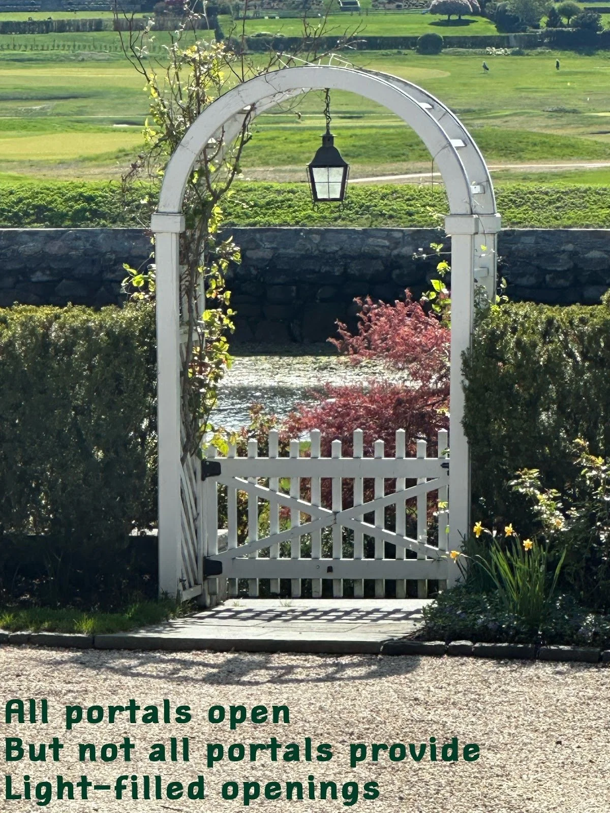 A white garden gate with an arched top and hanging lantern, surrounded by green bushes and plants, with a vineyard and a river in the background. A quote in green text at the bottom says, "All portals open But not all portals provide Light-filled openings."