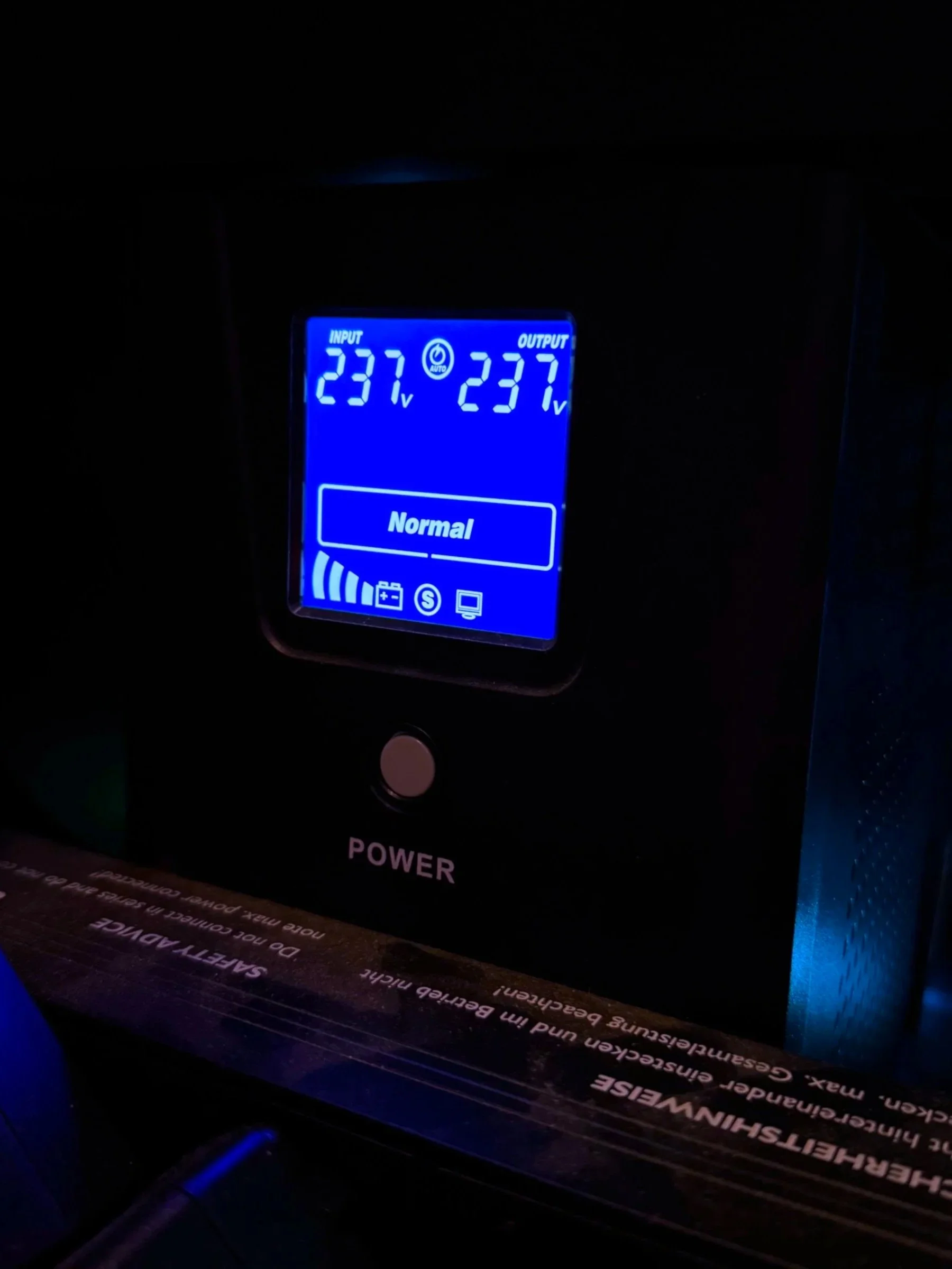 Schermo di un UPS con lettura di 237 volt input e output, con pulsante di accensione e indicatore di potenza.