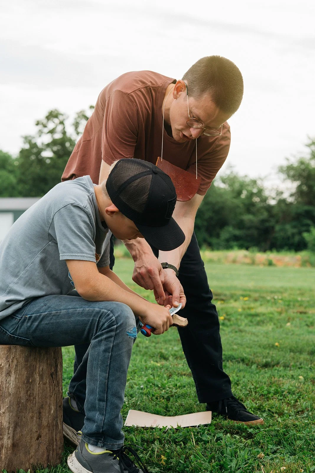 a teacher explaining a woodcarving grip to a student in a kids sloyd woodworking class