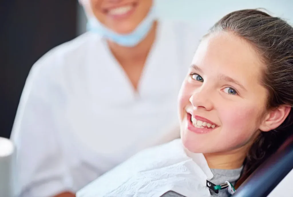 A young girl smiling at a professional dentist's office after her preventative dental cleaning