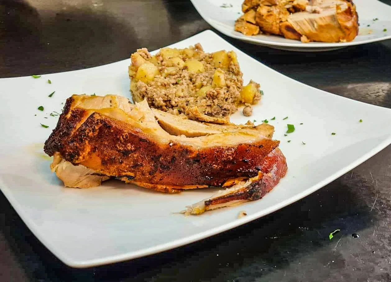 Geröstete Putenkeule mit Kartoffel-Bohnensalat auf einem weißen Teller