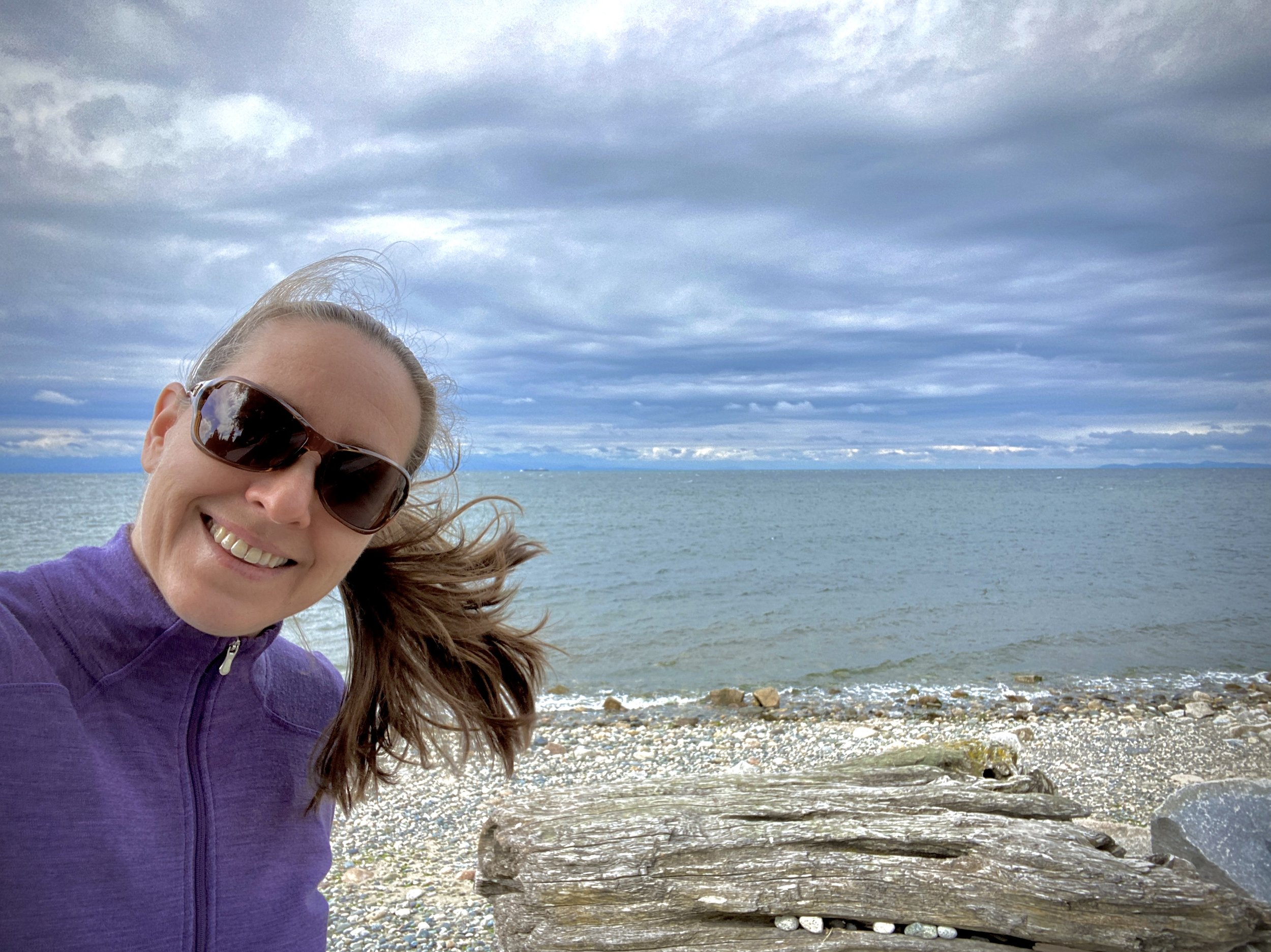 Lady on the beach with big clouds in the sky