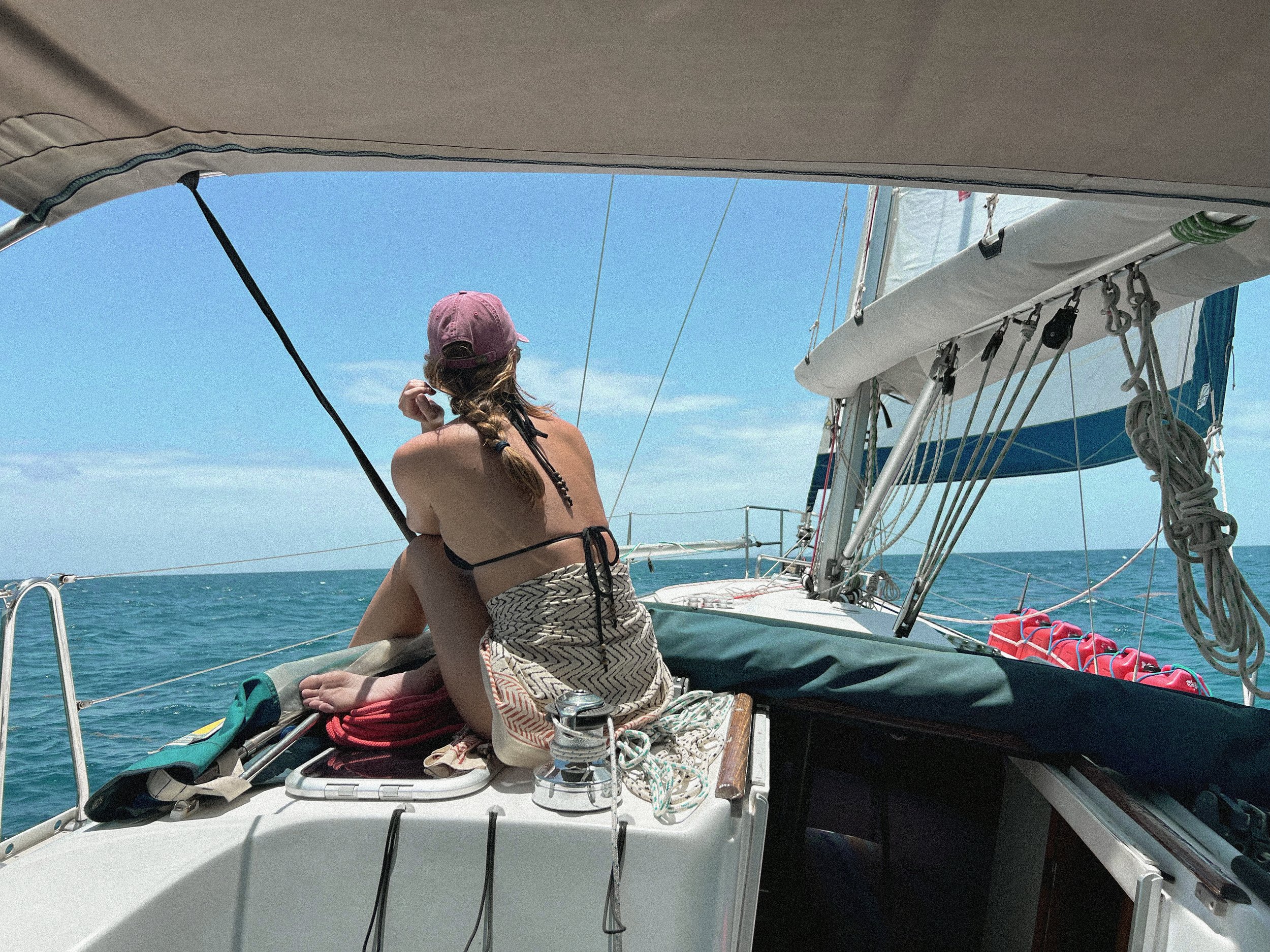 A young woman sitting on the deck of Sailing Vessel Nayru in Barbados