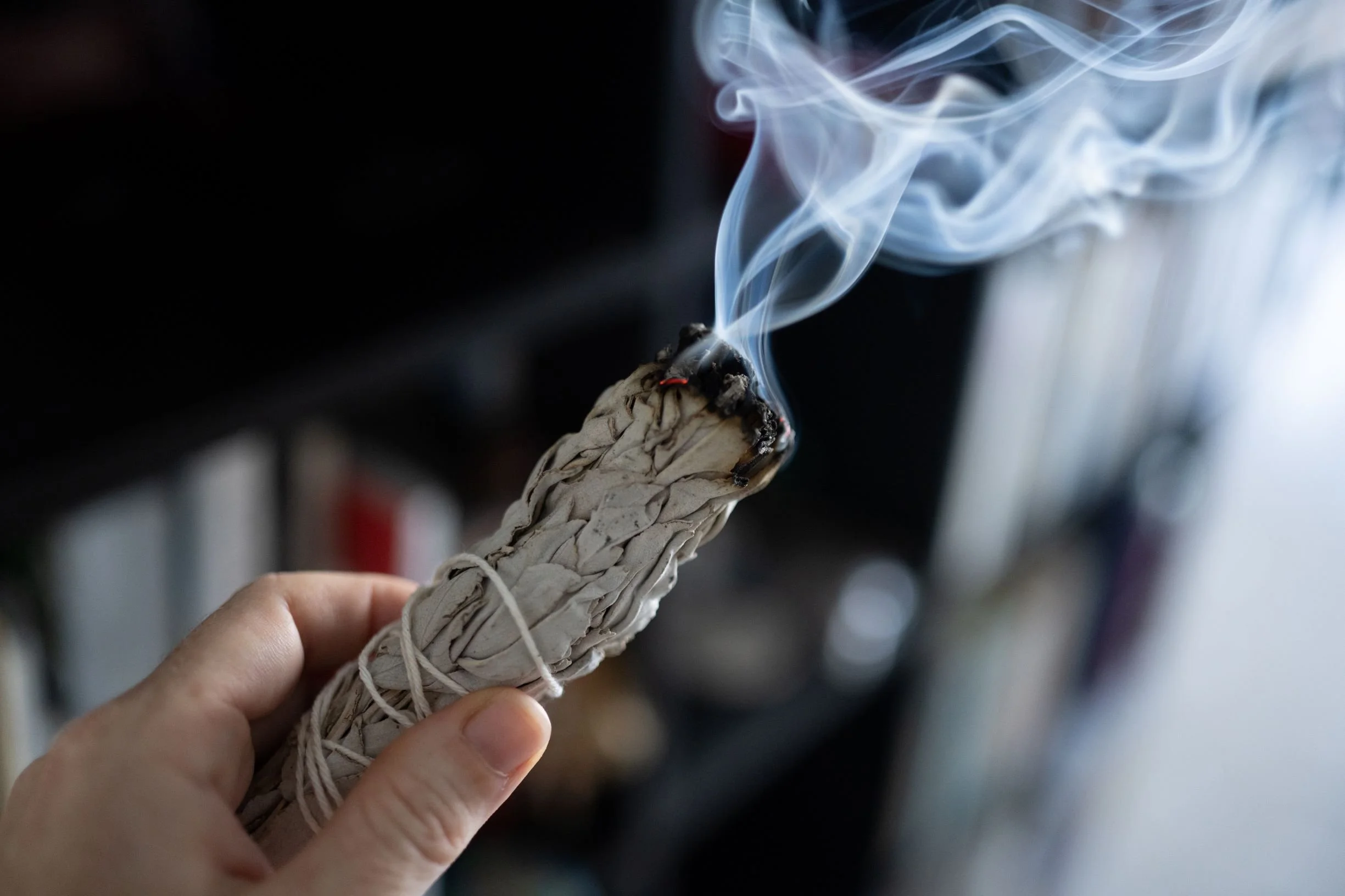 Une personne tenant de la sauge enflammée lors d'une cérémonie de purification.