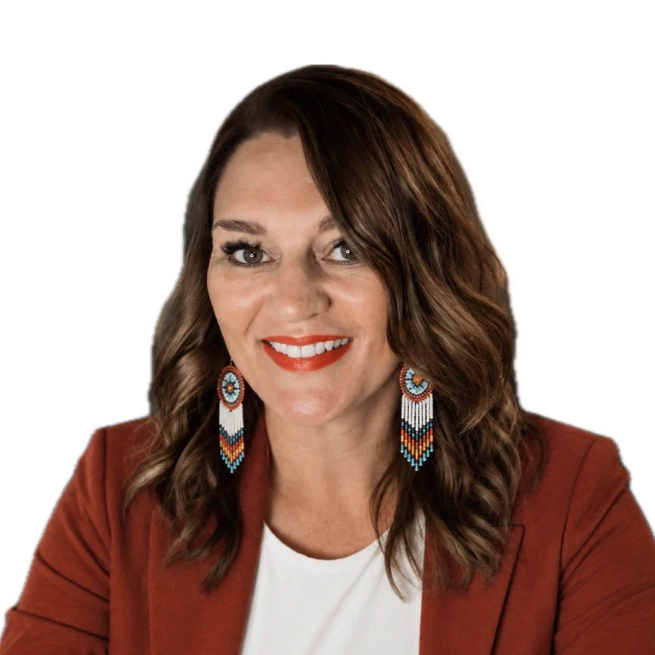 Nista Simms-Noel, a smiling woman with wavy dark hair wearing beaded earrings and a rust-colored blazer.
