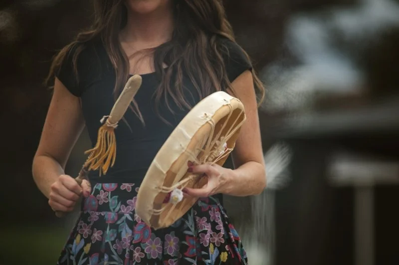 First Nation woman drumming.