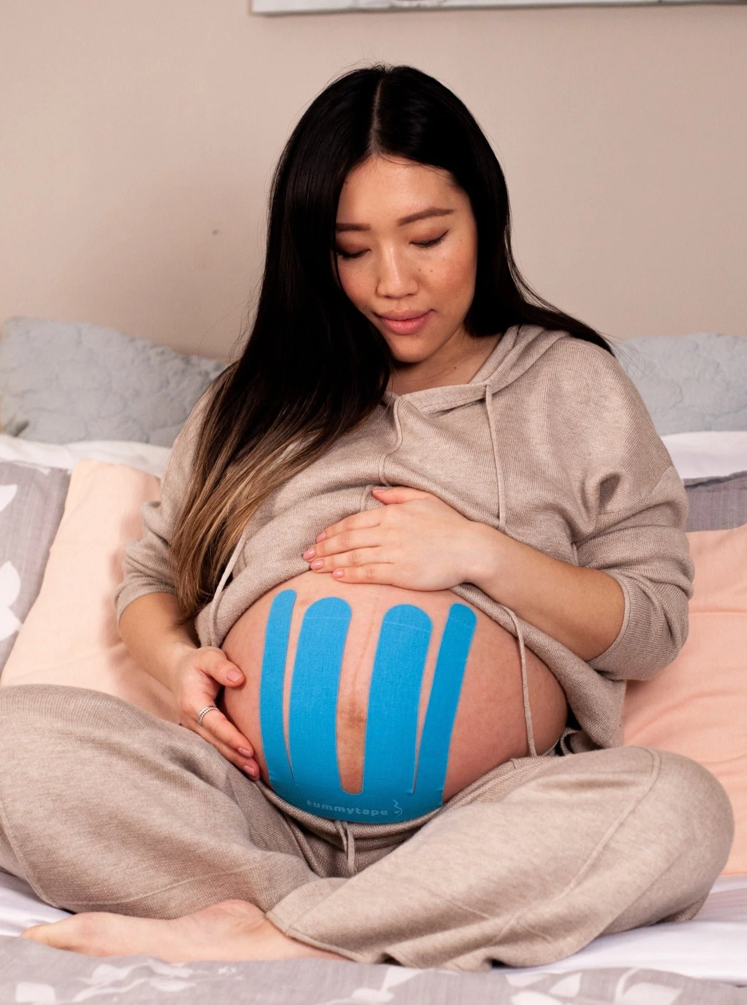 Kinesiotape located on a pregnant moms belly to help provide support