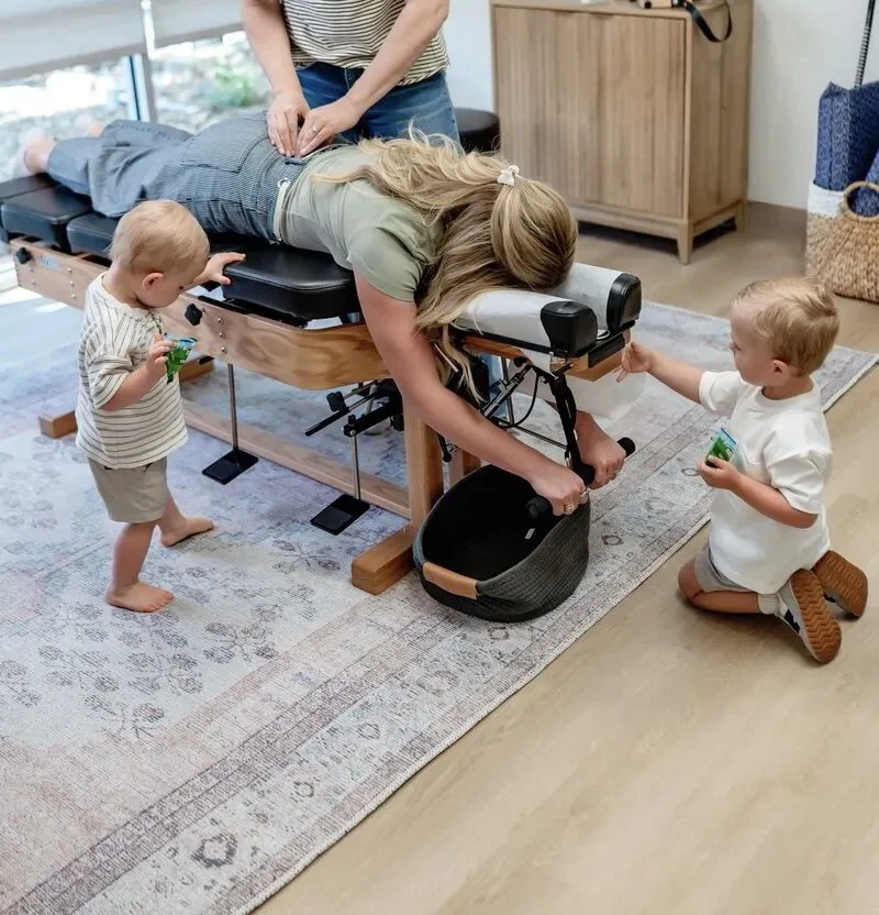 Mom getting adjusted with kids playing around her