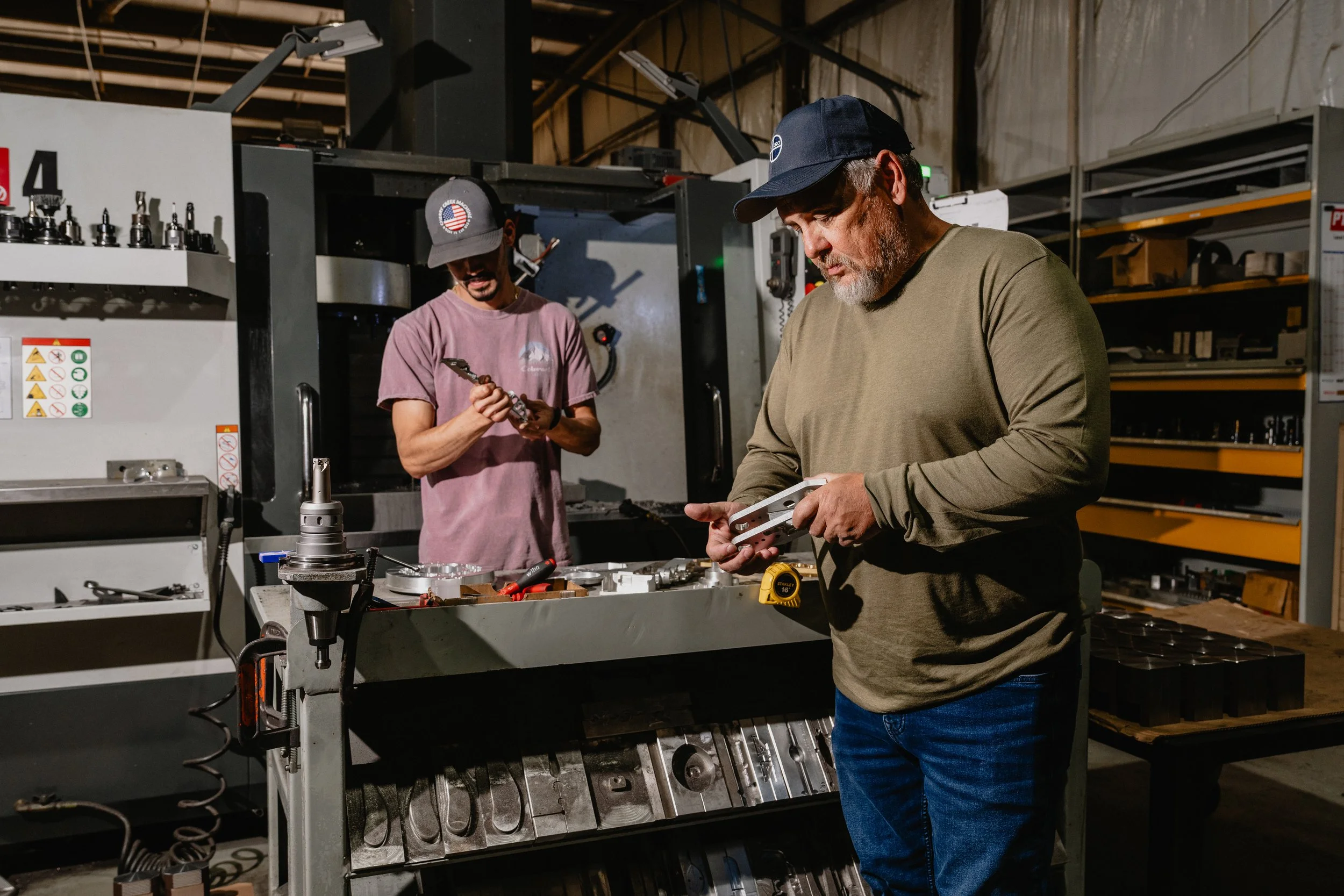Two machinists working in front a Haas CNC mill in Tulsa OK manufacturing aerospace, energy, and construction components..