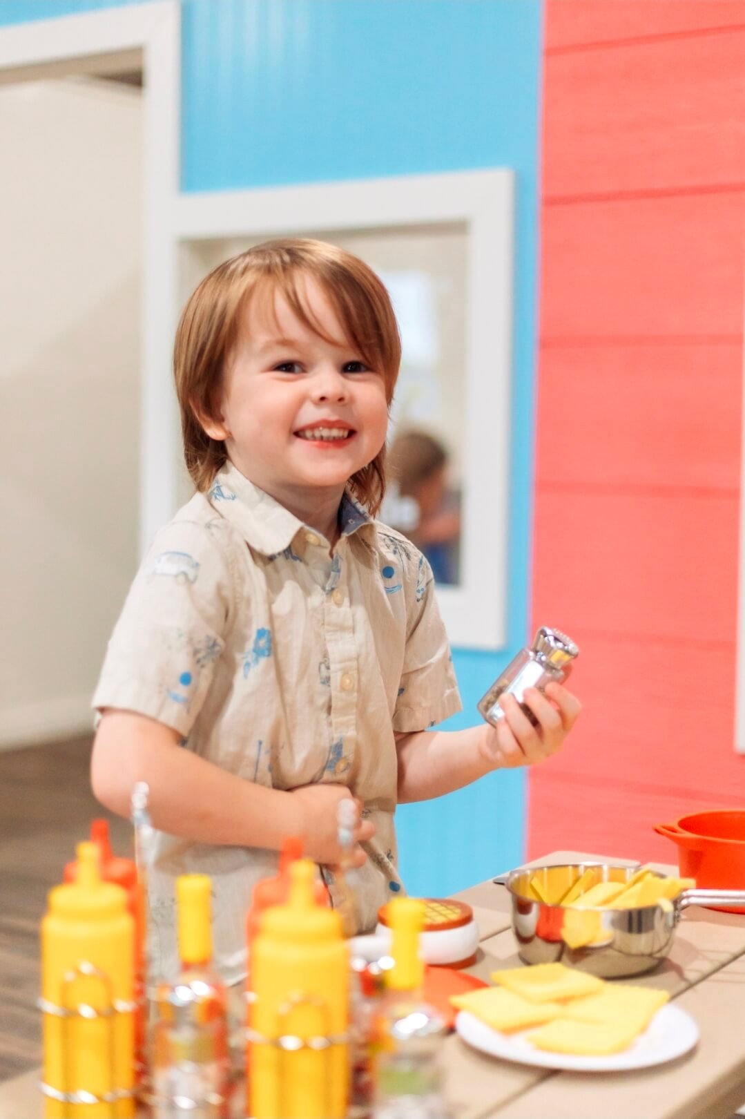 Little boy playing in kitchen at The Duckling Village in Tyler, Texas.