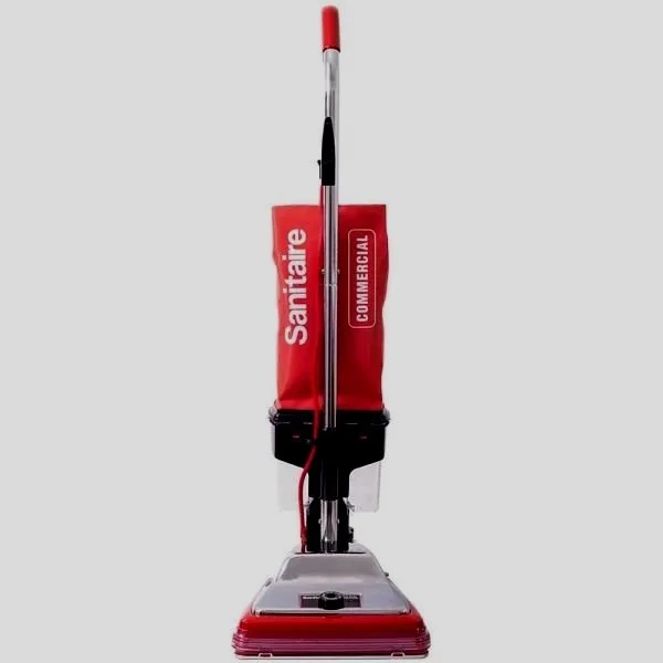 A commercial Sanitaire with a red and white handle, a red cleaning pad, and a red bag labeled 'Sanitaire Commercial'.