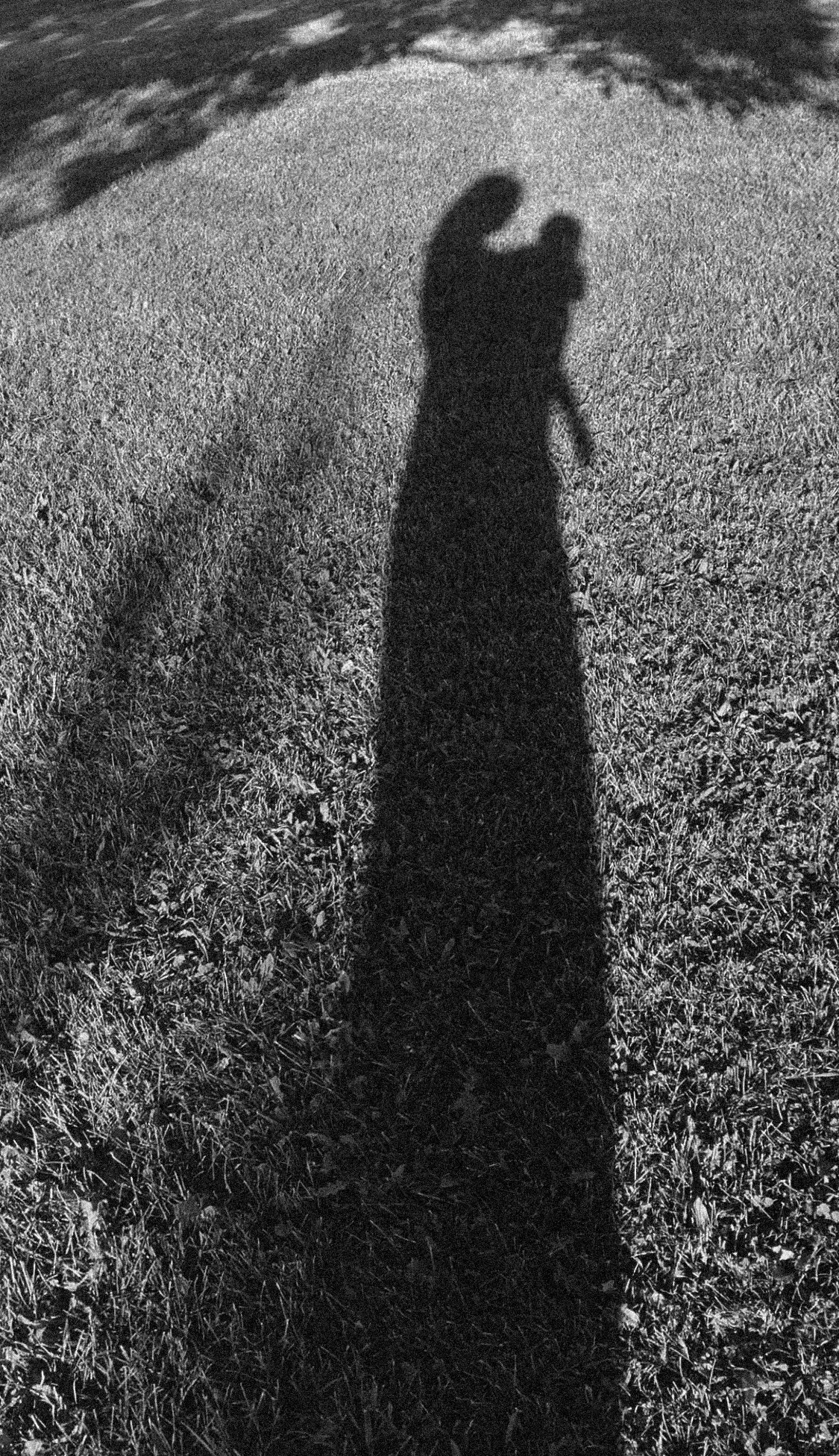 Long shadow of a person holding a toddler