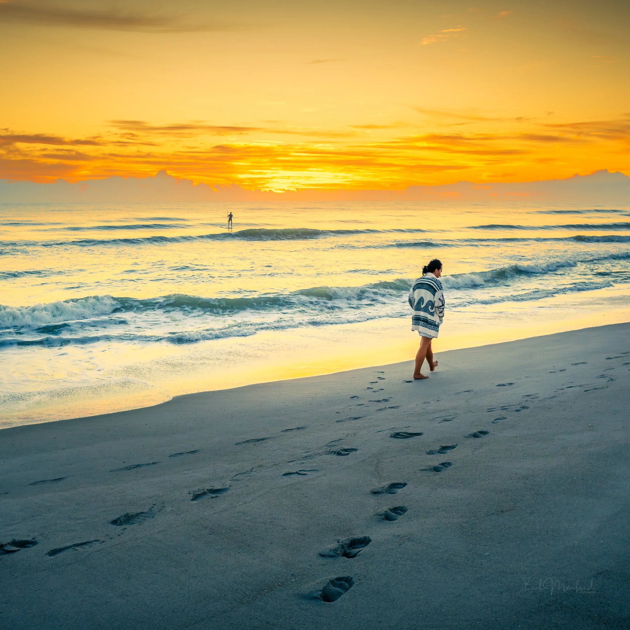 Footprints in the sand with a golden sky