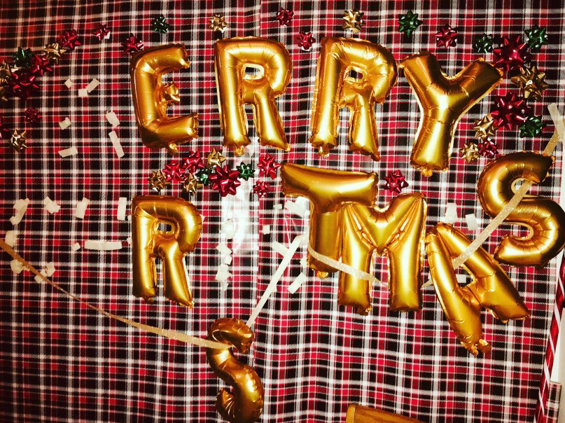 Franklin Barbecue photo of Merry Christmas balloons on a wall with several letters fallen off.