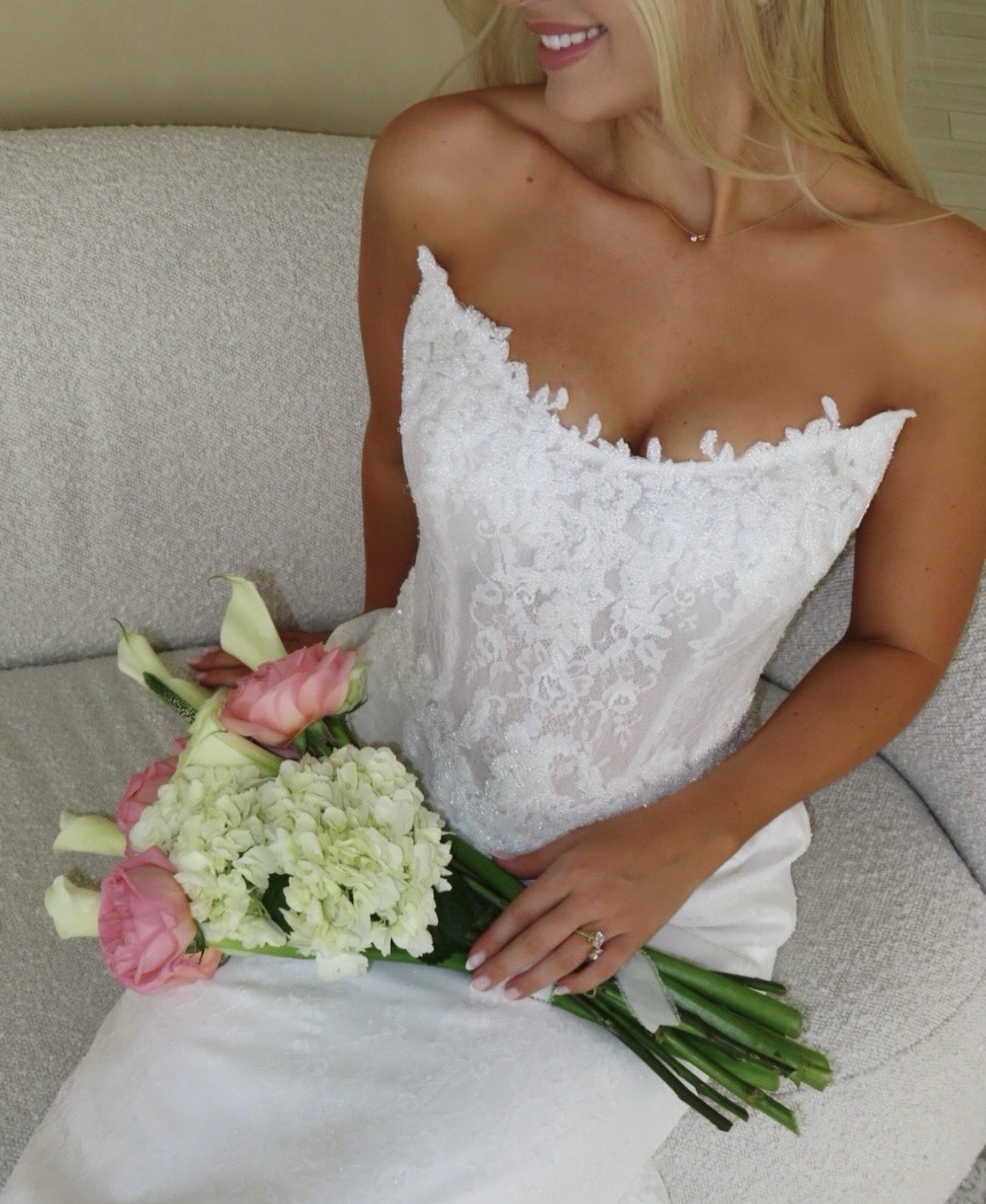 brand photos taken in 480 natural light studio close up of bride in beautiful white lace corset wedding dress with simple flowers on white minimalistic boucle couch