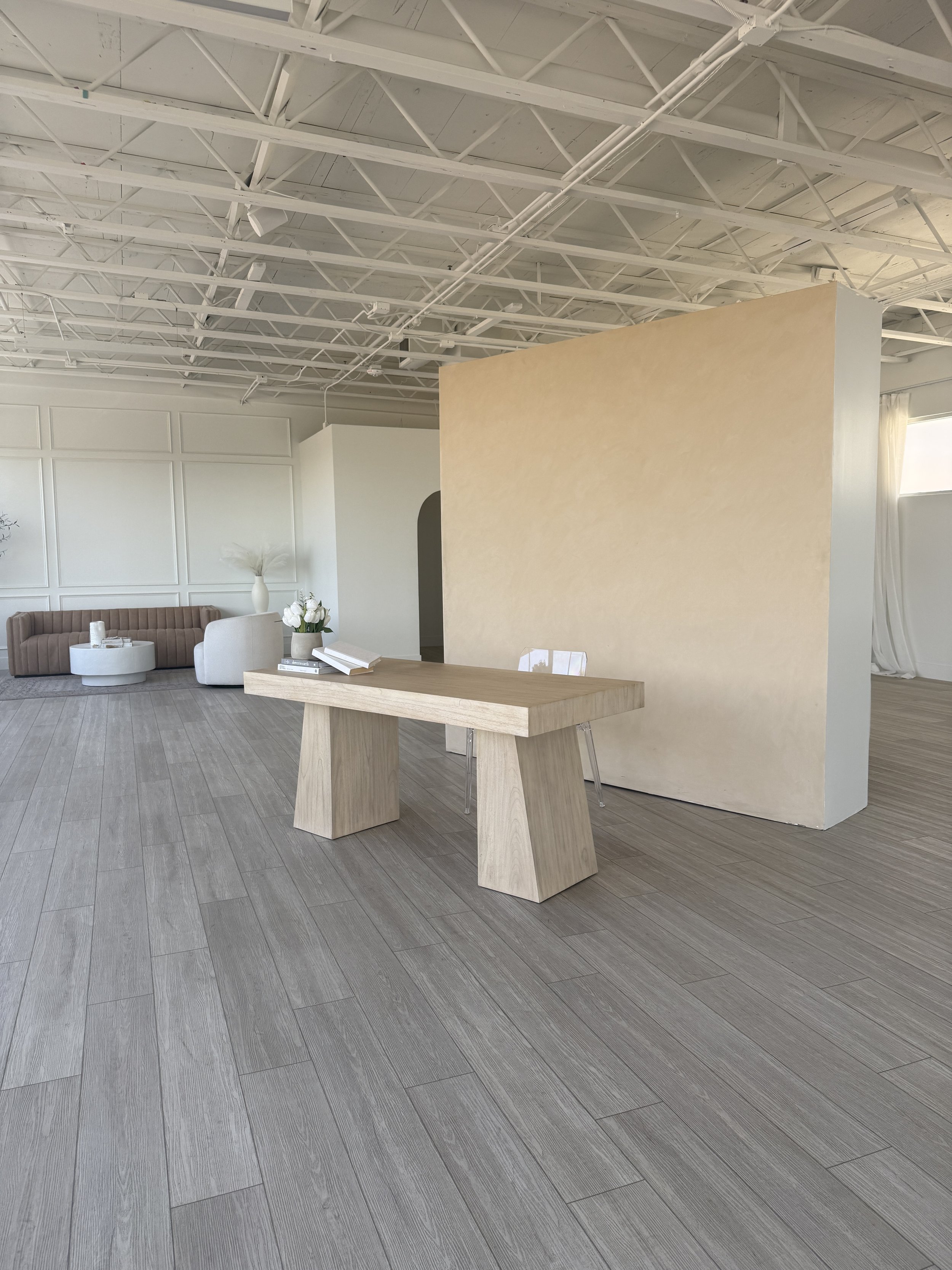 reversible lime wash wall for photography, natural light space and CB2 modern light wood desk with clear acrylic chair