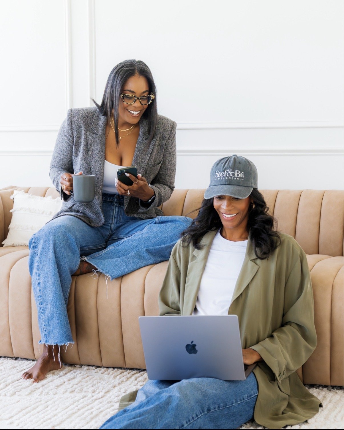 brand photos taken in 480 natural light studio 2 women in jeans modern aesthetic sitting on couch with laptop i