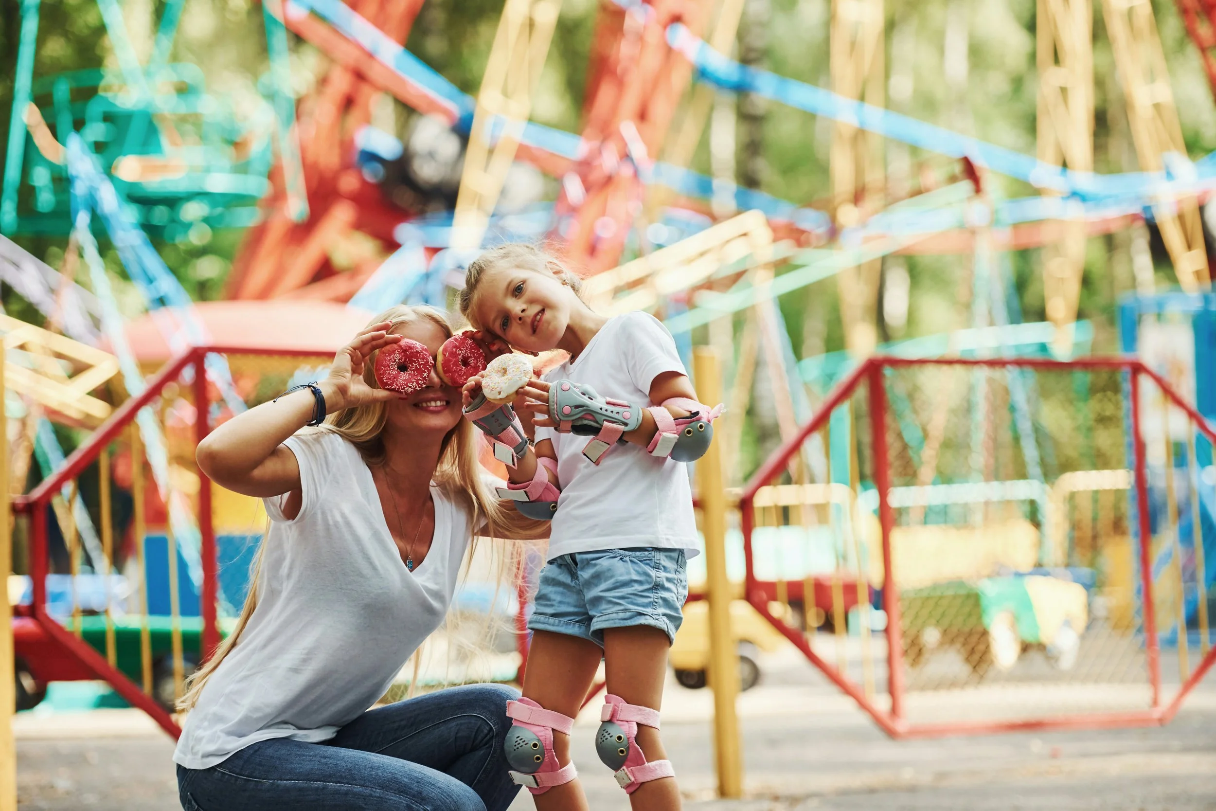 a mother and child at the playground holding donuts