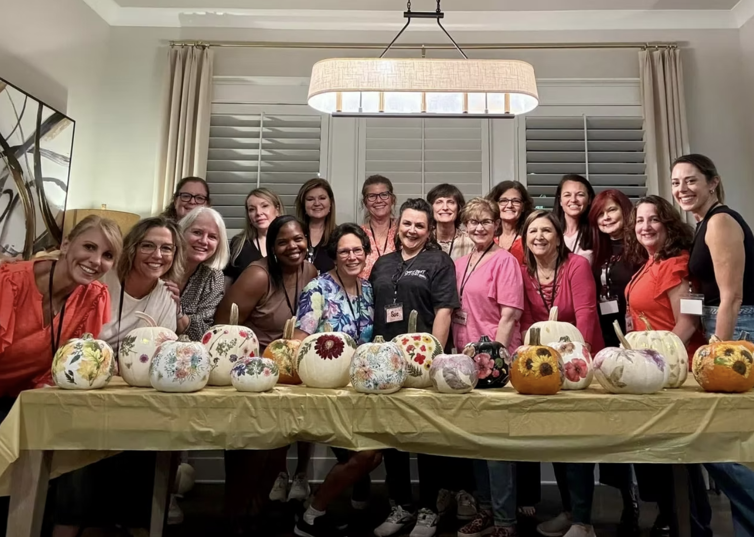 Widows Who Wine members standing with decorated pumpkins