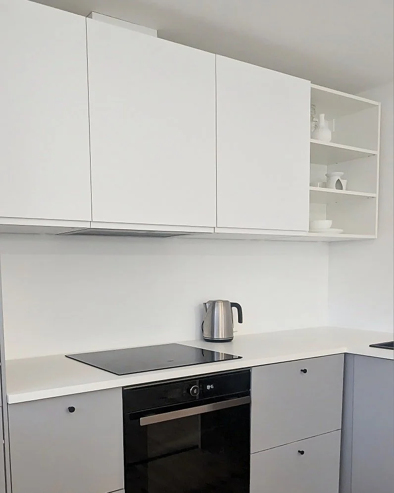 Minimalistlik köök, kus hallid alumised kapid ja valged ülemised kapid loovad elegantse kontrasti 🤍✨. Must kraan ja tehnika ⚫ lisavad modernset aktsenti, samal ajal kui soe puidust põrand 🌿 tasakaalustab terviku. Hea näid