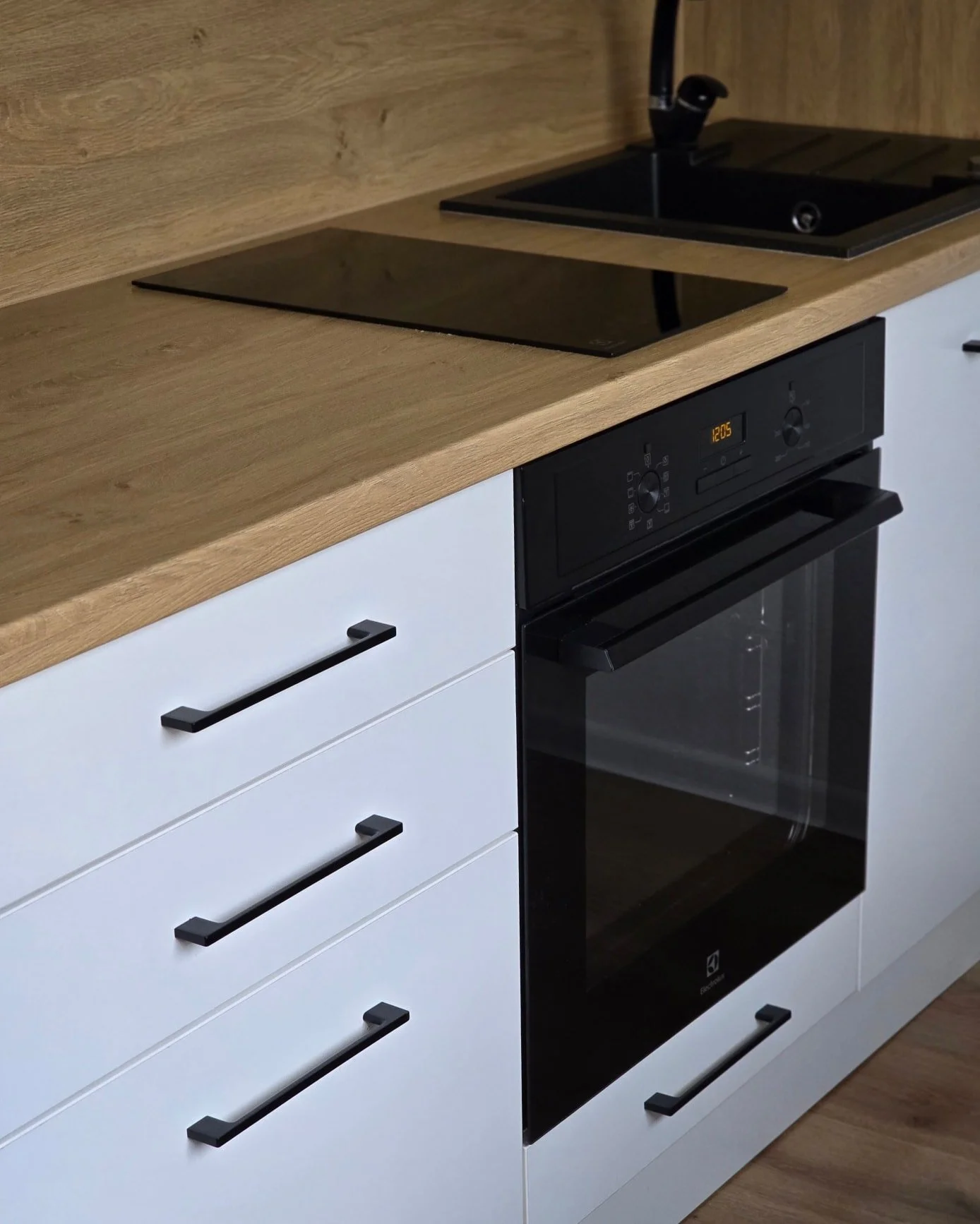 Valge köök tamme tööpinnaga
✨ Minimalistlik ja praktiline lahendus igapäevaseks kasutamiseks!
Selles köögis on kasutatud valget melamiinkattega plaati ning tammepuidu tooni tööpinda ja taustapaneeli, mis