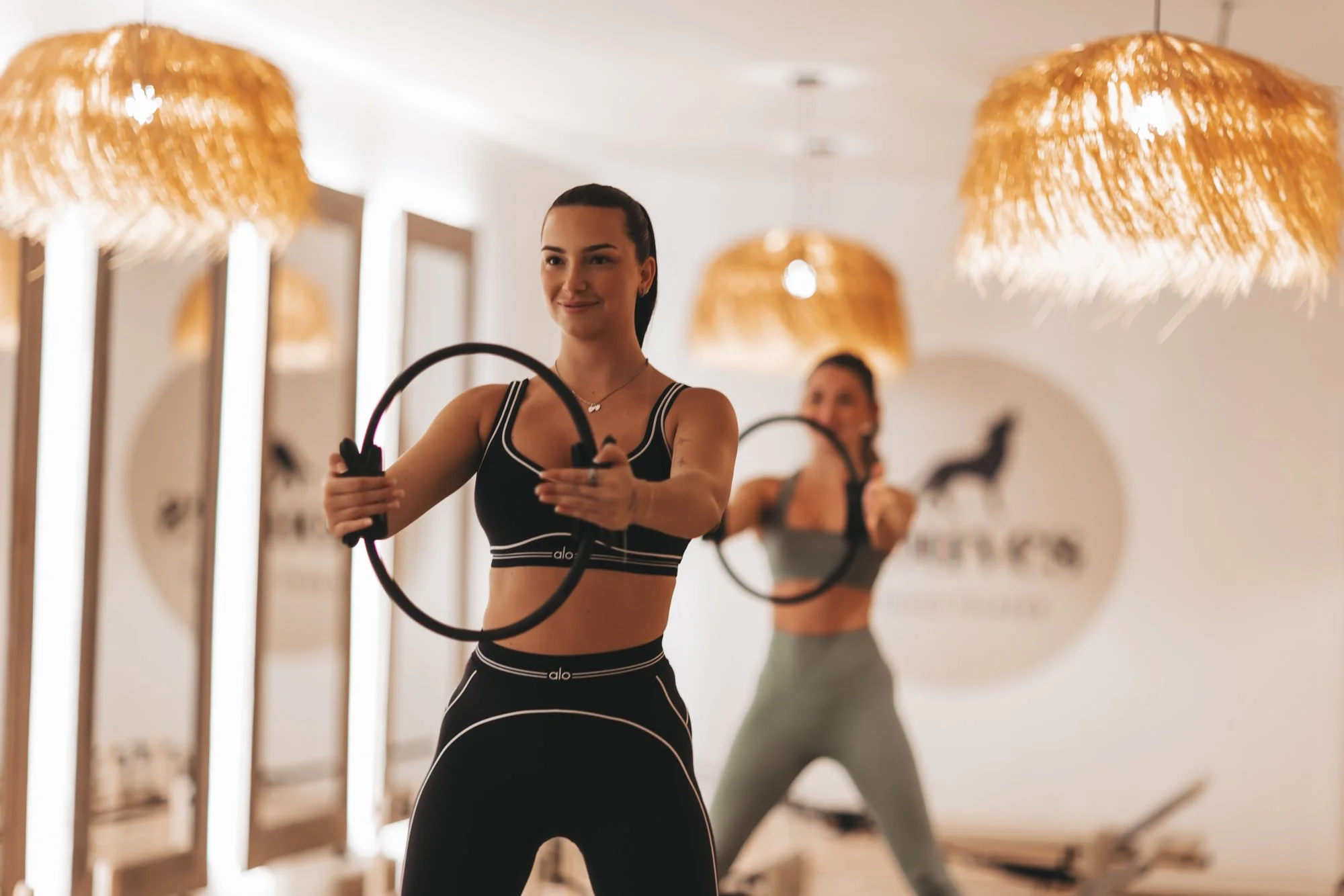 Deux femmes faisant de l'exercice avec des cercles de fitness dans une salle de sport moderne