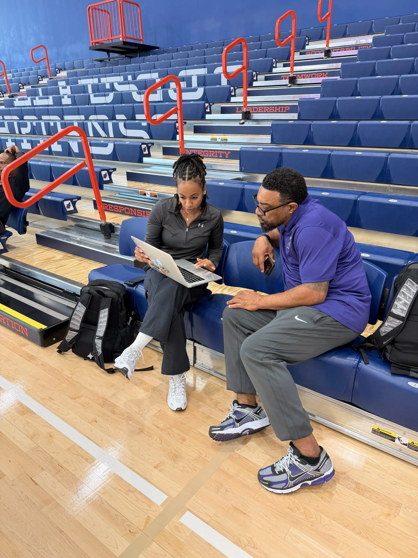 Athletes and coaches reviewing performance and development strategies during a basketball event.