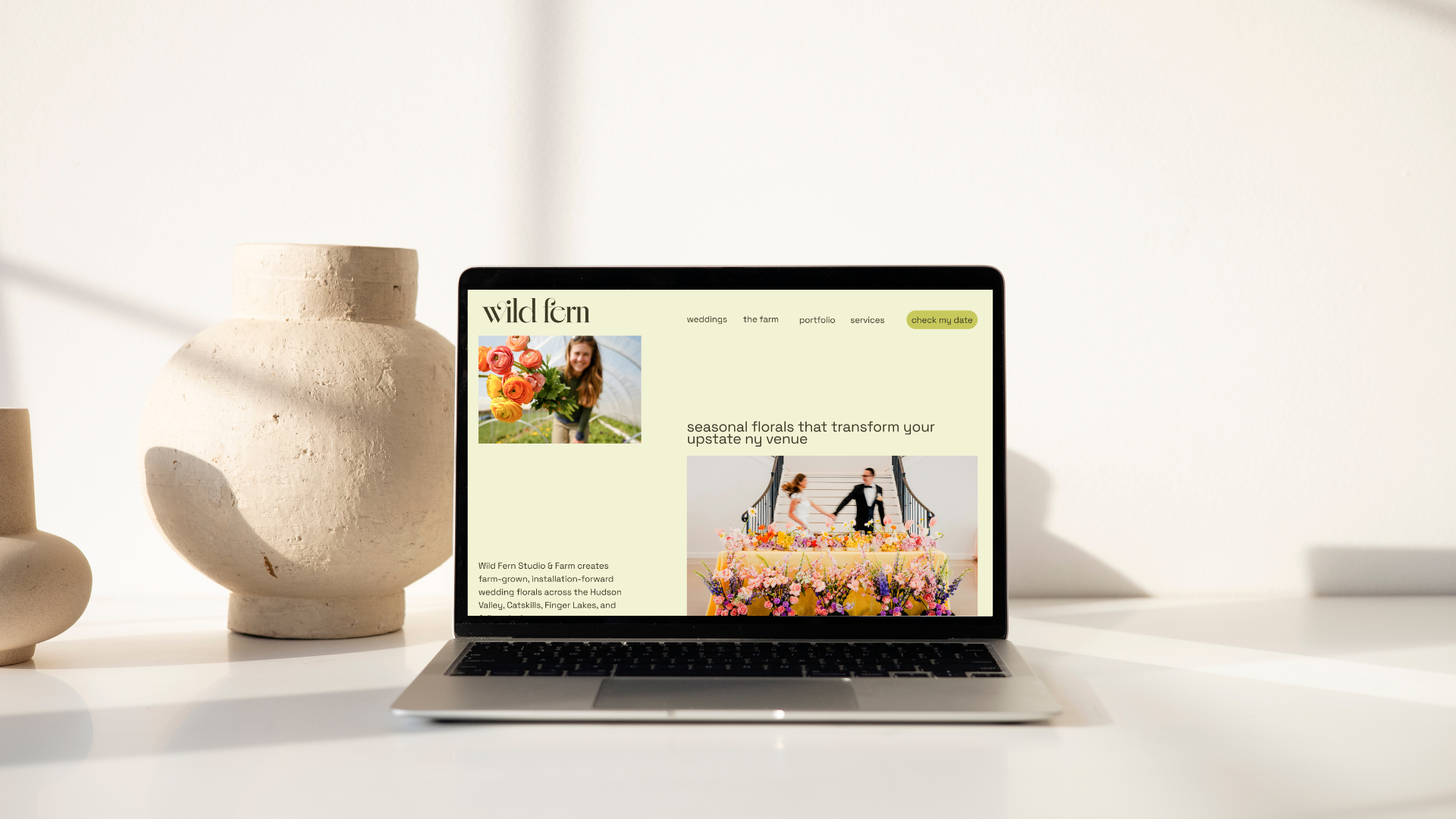 A laptop on a pristine desk showing a website for a floral designer and flower farm called "Wild Fern"