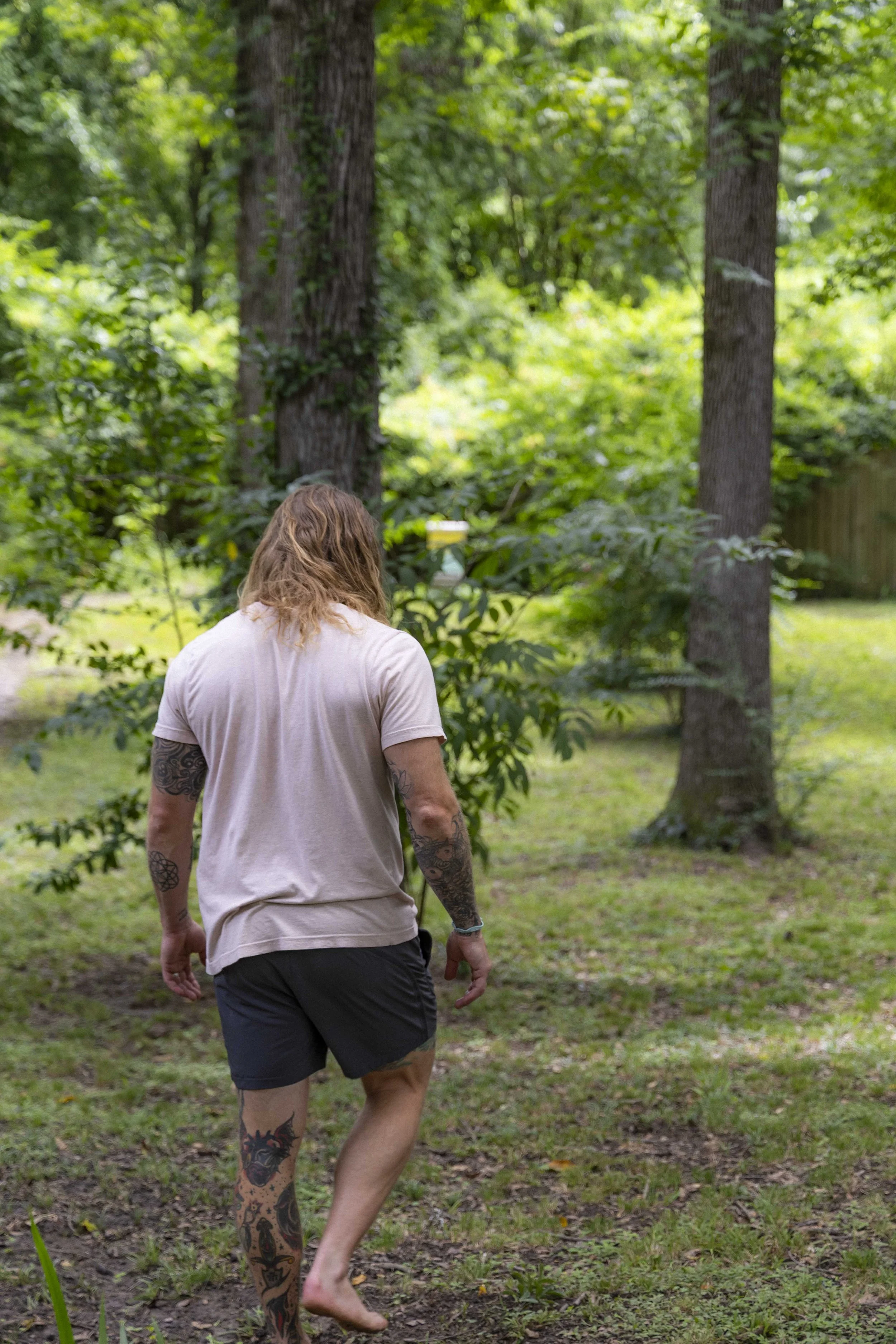 Founder Chris walking barefoot through the woods, reflecting on holistic wellness and mental health
