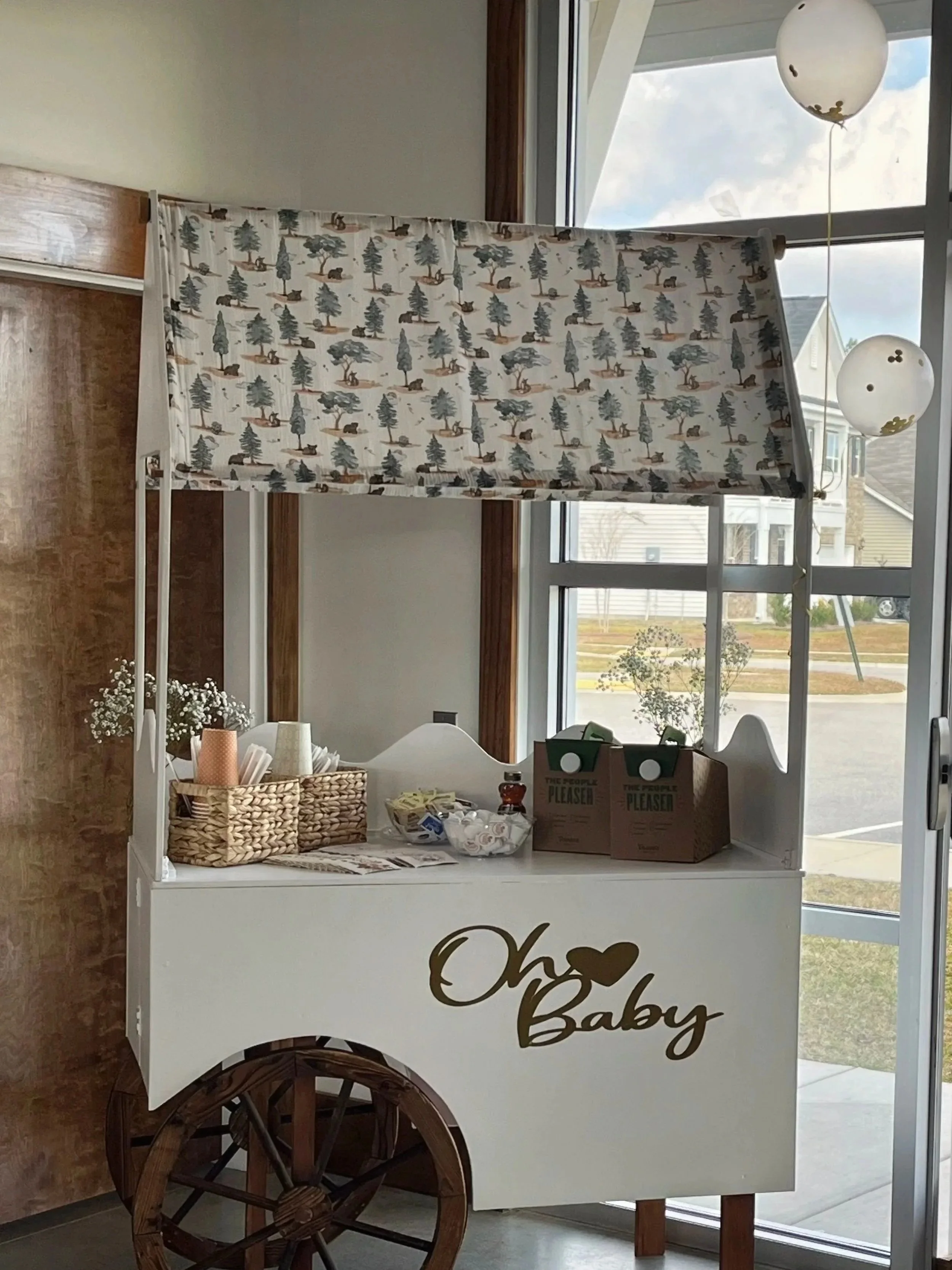 A landscape with snow-capped mountains in the background and a modern building in the foreground on rolling green hills.