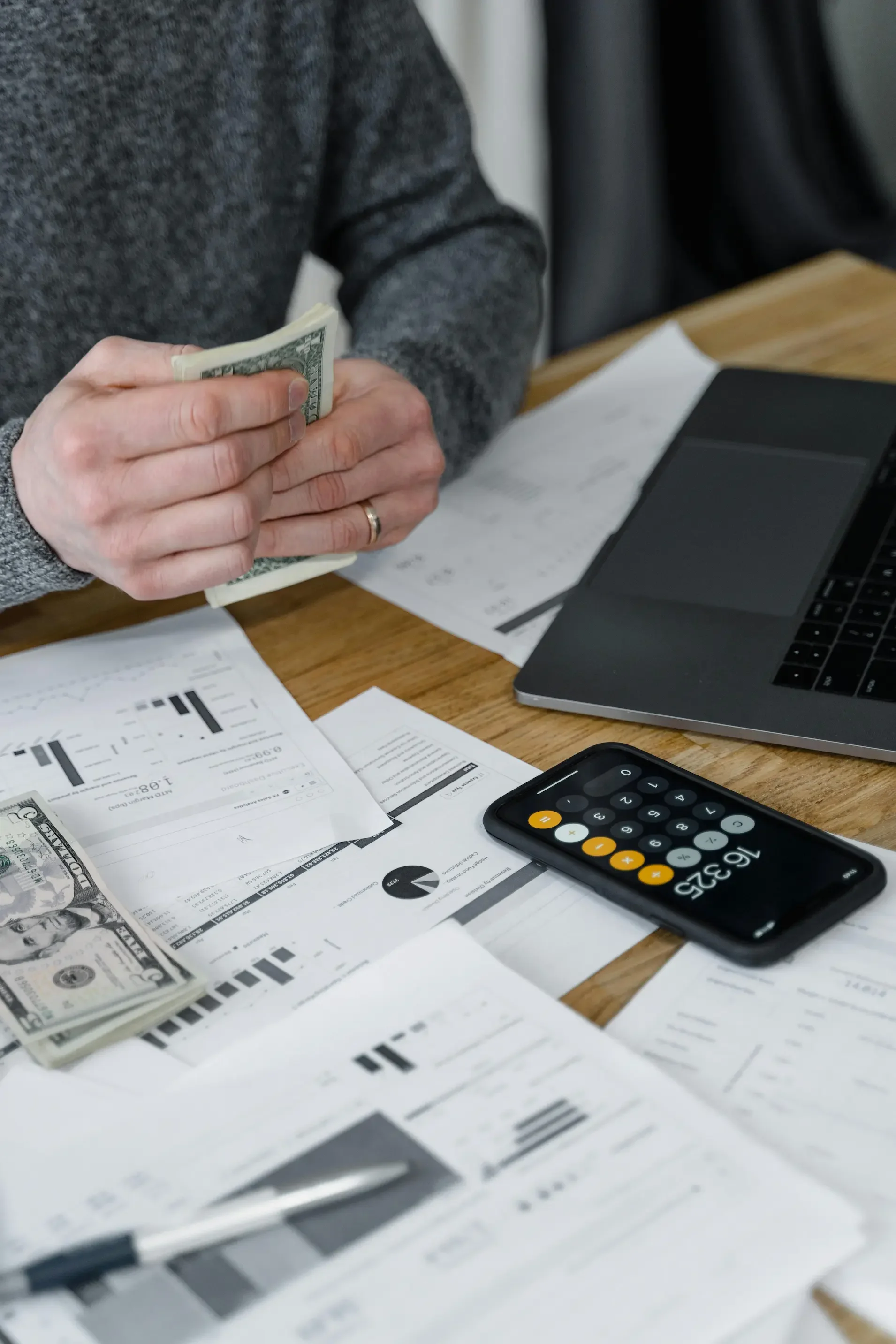 A person carefully managing finances and household expenses, representing the stress and focus required for financial planning.