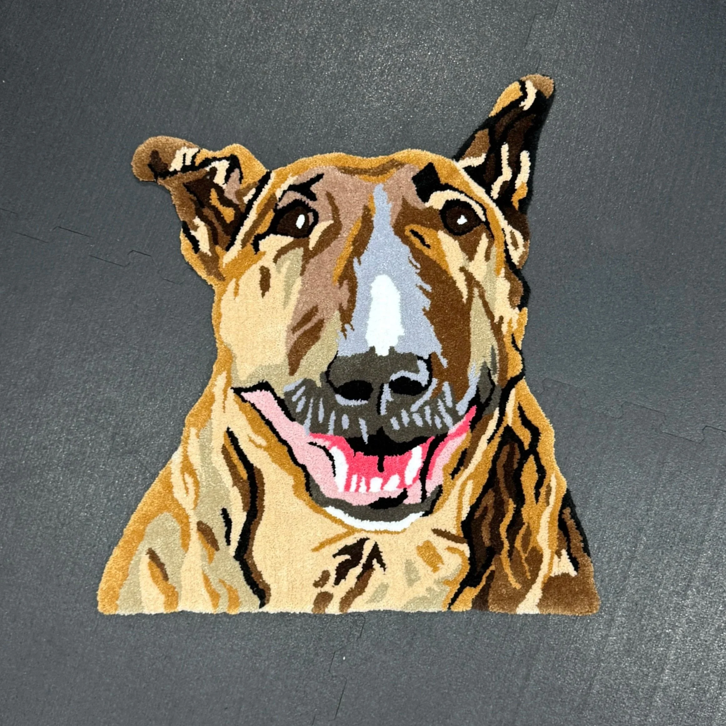 Colorful woven rug depicting a happy dog with a brown coat, black nose, and an open mouth showing a pink tongue.