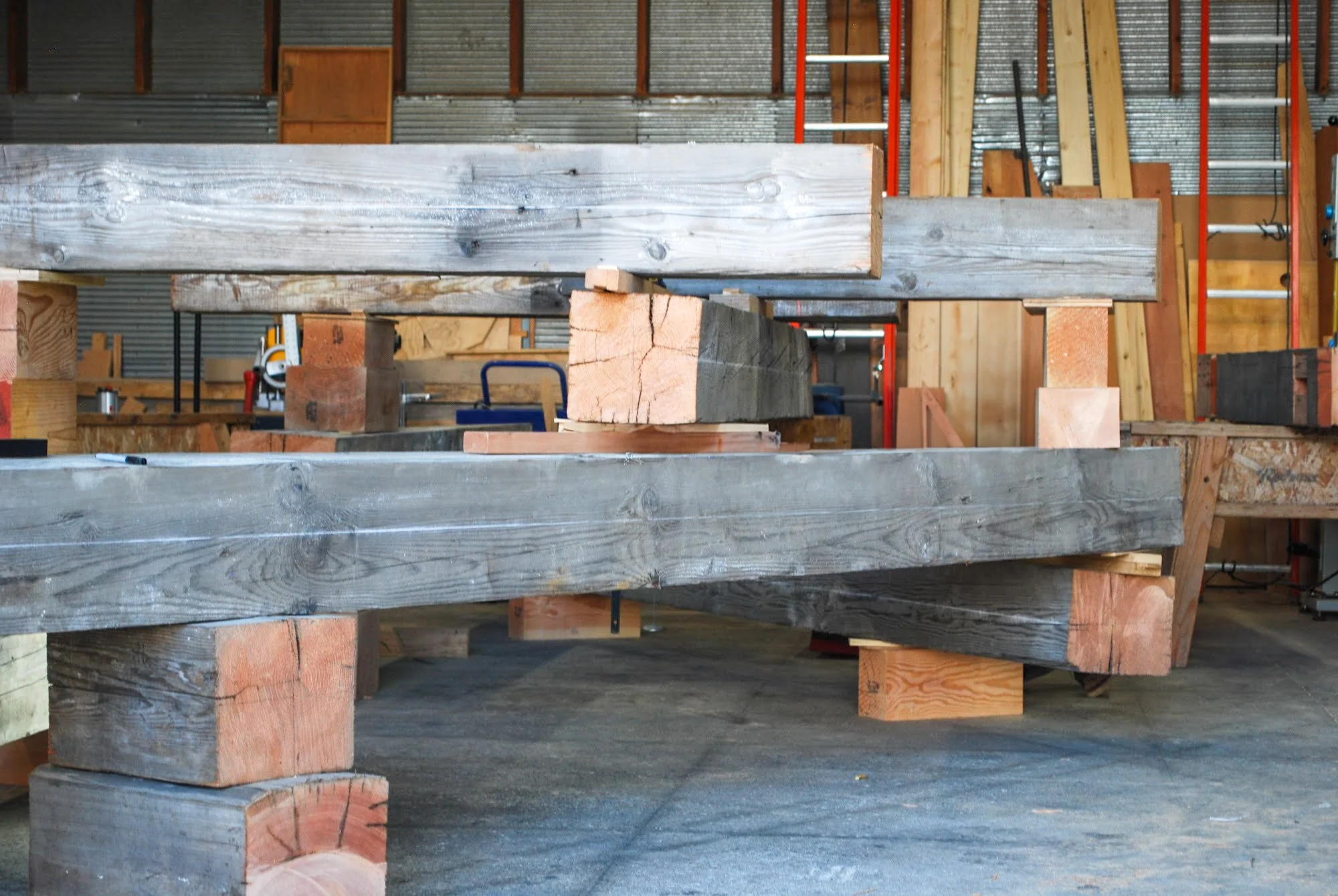 Wooden beams and blocks arranged in a workshop setting.