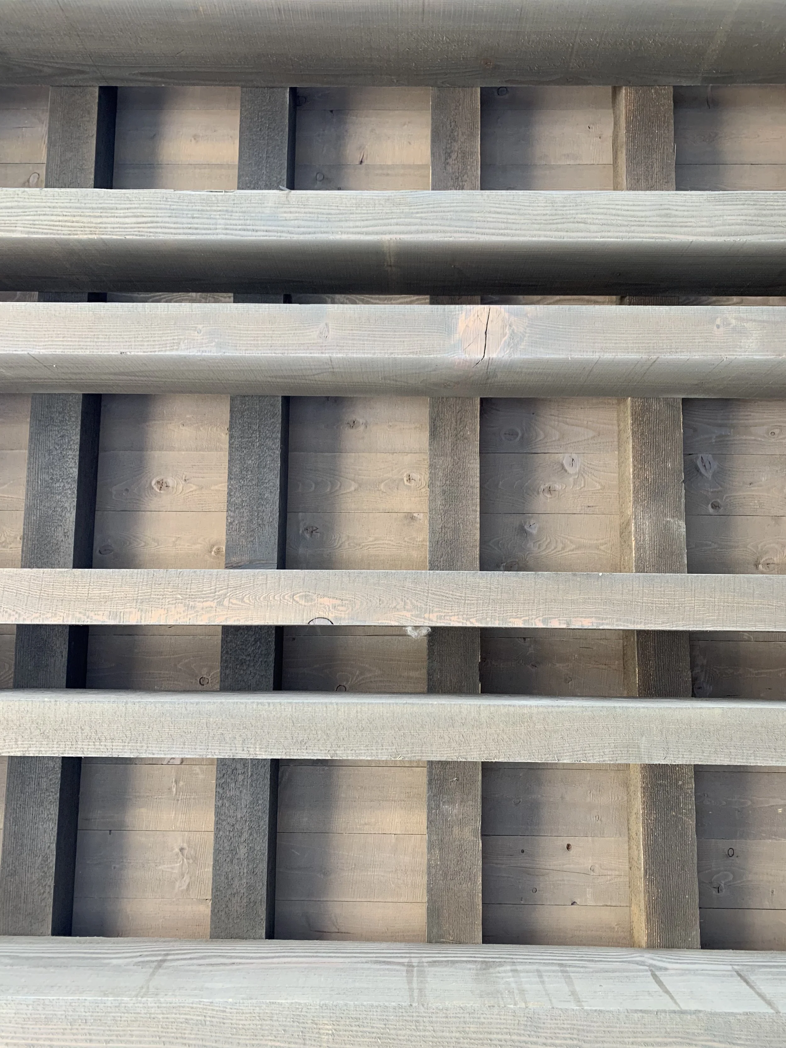 Close-up of a wooden deck or staircase with horizontal and vertical wooden planks.