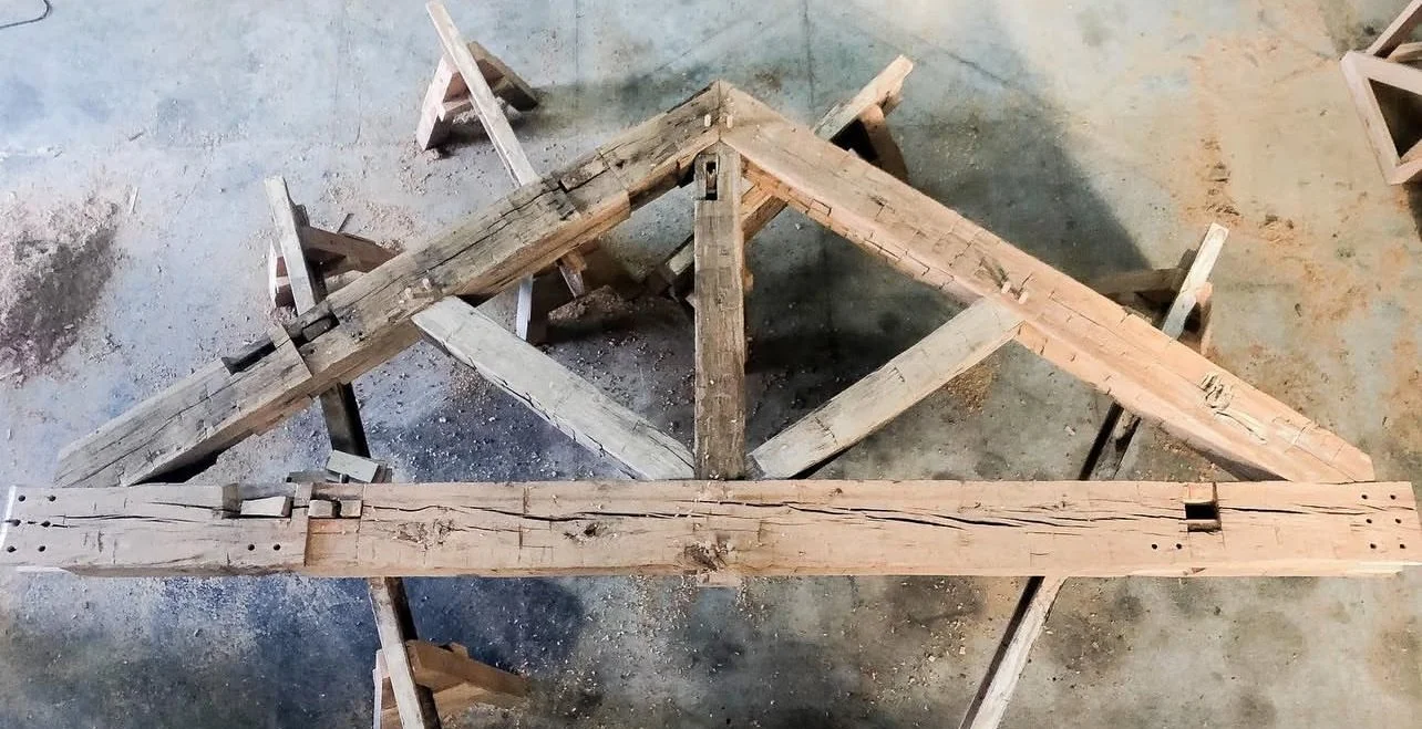Wooden construction frame supported on saw horses in a workshop.